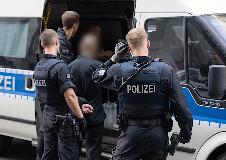 Polizisten führen in einem Kriminalitäts-Brennpunkt während einer Kontrollaktion einen Mann zur Personalienkontrolle. 