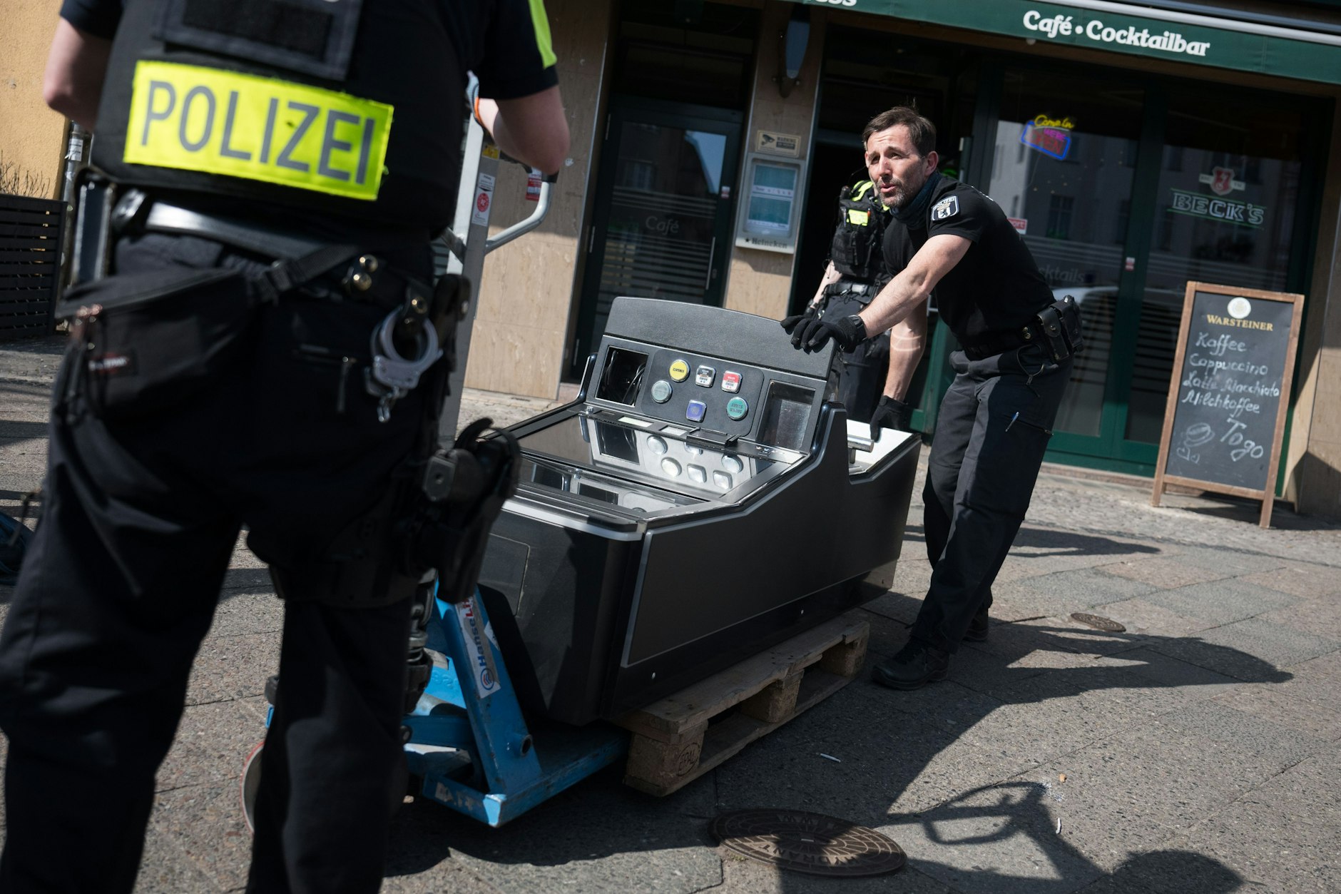 Beamte transportieren einen Spielautomaten aus einem Lokal. Mit Durchsuchungen an 80 Orten in Berlin sind Justiz, Polizei und Bezirke gegen die Organisierte Kriminalität und illegales Glücksspiel vorgegangen.