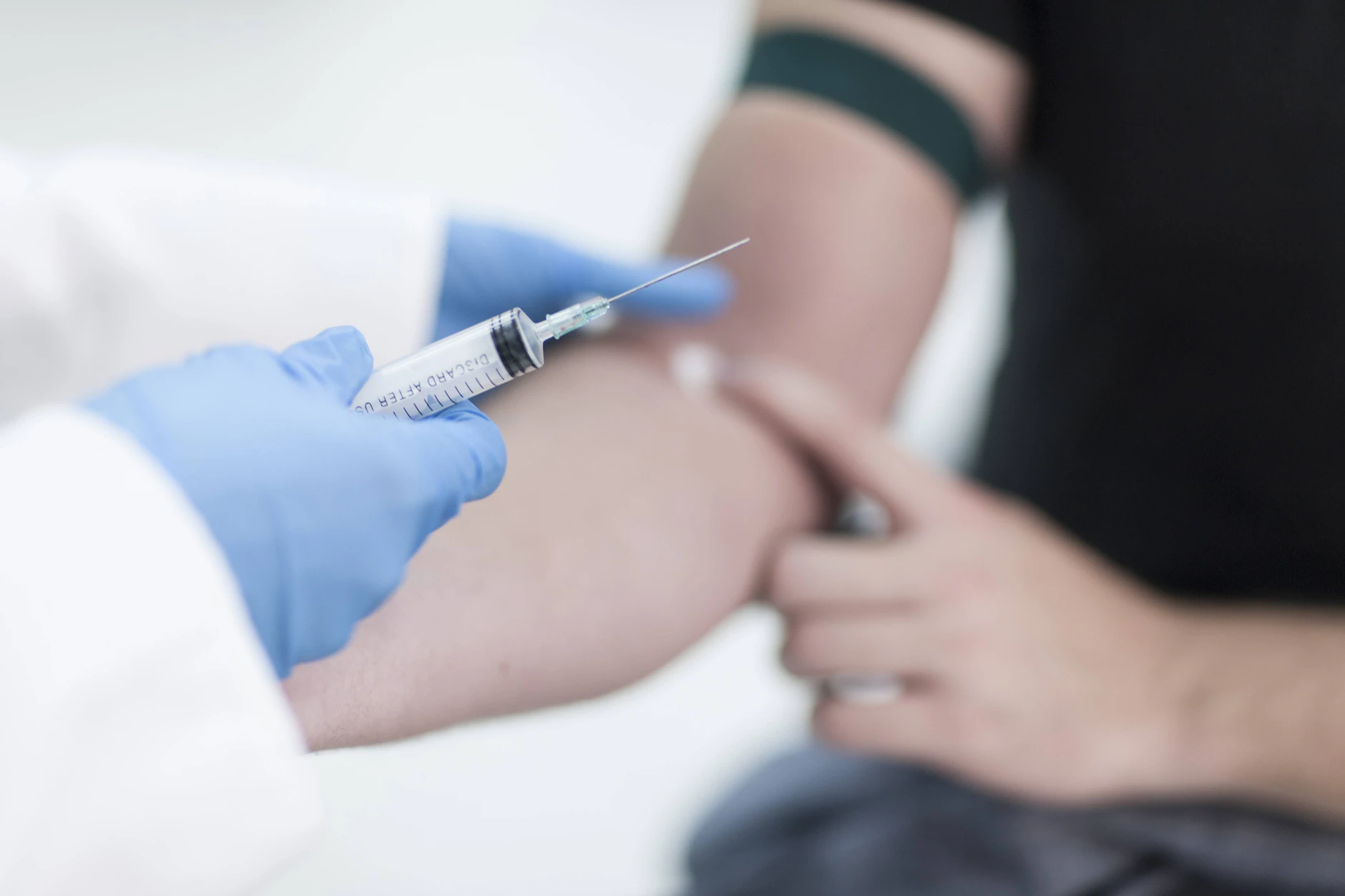 Einem Praxisbesucher wird Blut abgenommen.