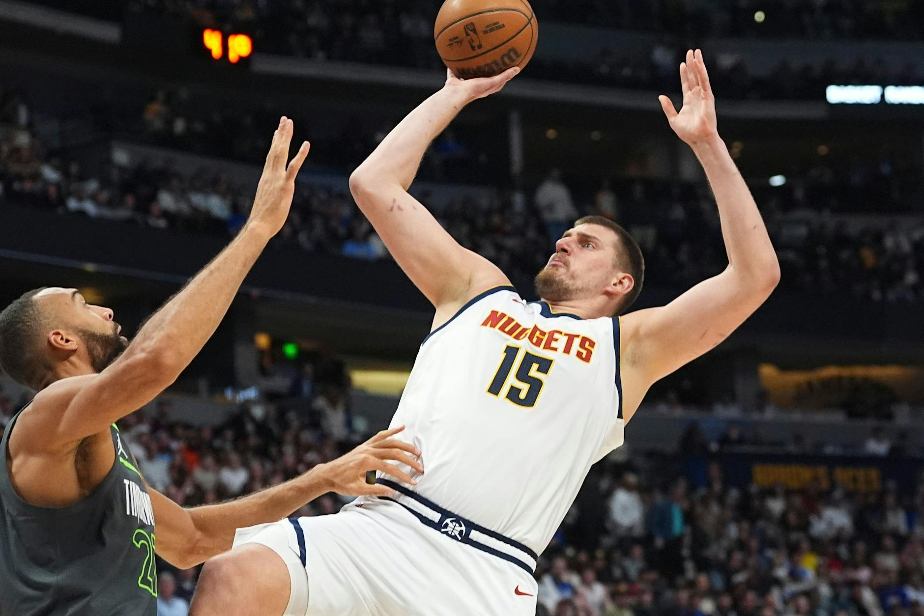 Denver Nuggets-Center Nikola Jokic (r) wirft in der ersten Hälfte des Spiels einen Korb über Minnesota Timberwolves-Center Rudy Gobert.