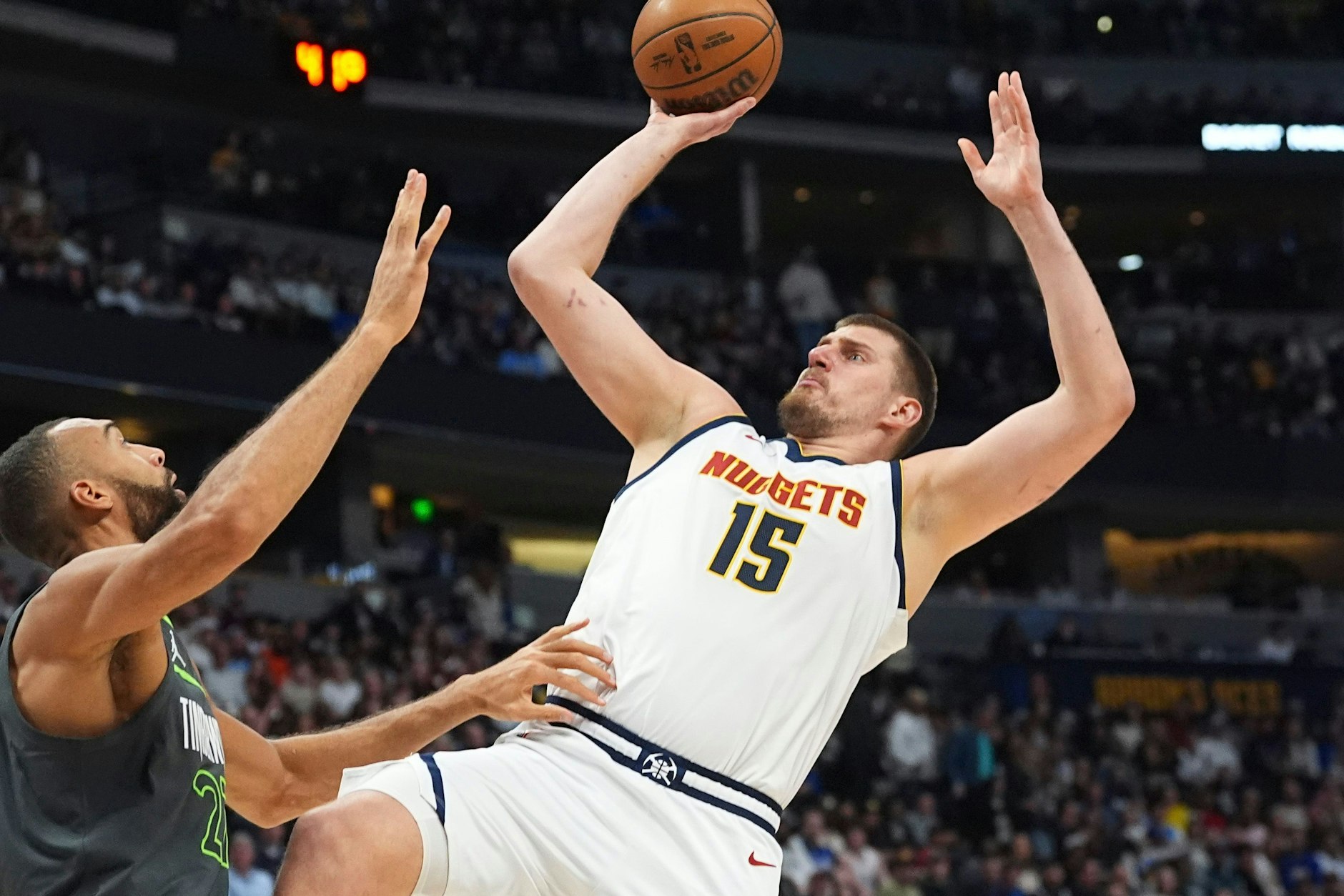 Denver Nuggets-Center Nikola Jokic (r) wirft in der ersten Hälfte des Spiels einen Korb über Minnesota Timberwolves-Center Rudy Gobert. 