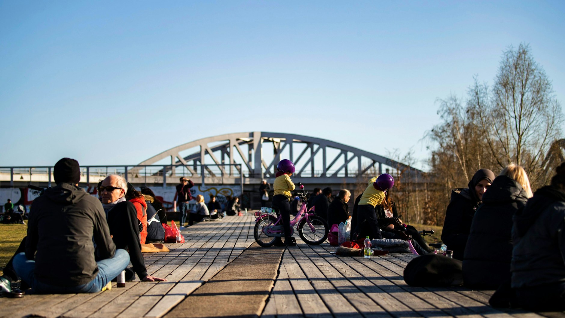 Menschen genießen an einem Sonntag die Sonne am Gleisdreieckpark in Berlin.