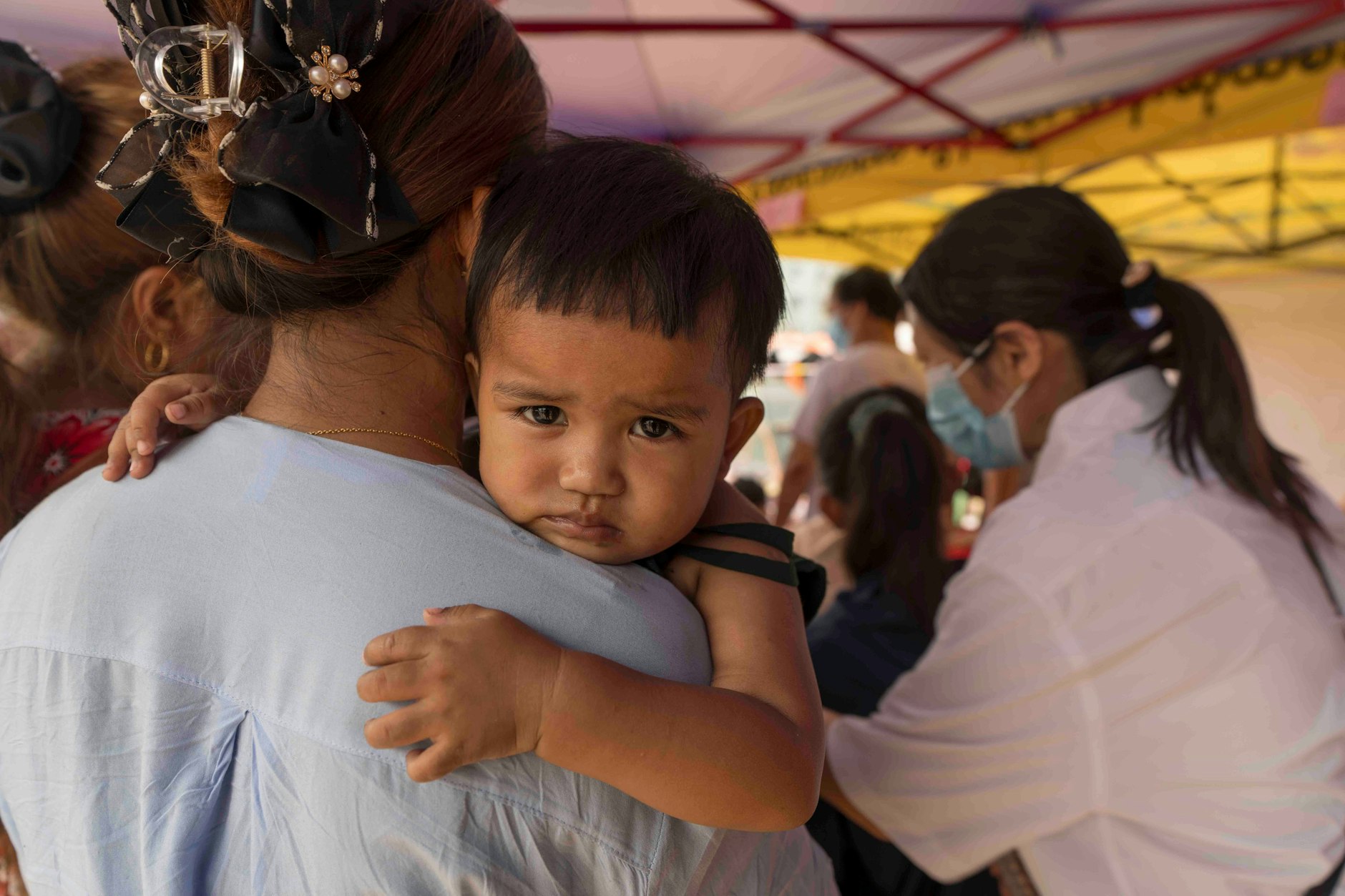 Ein verheerendes Erdbeben der Stärke 7,7 hat Myanmar und Teile Südostasiens erschüttert. Eine Frau bringt ihr Kind zu einer medizinischen Untersuchung in eine Unterkunft in Mandalay, Myanmar, 3. April 2025. 
