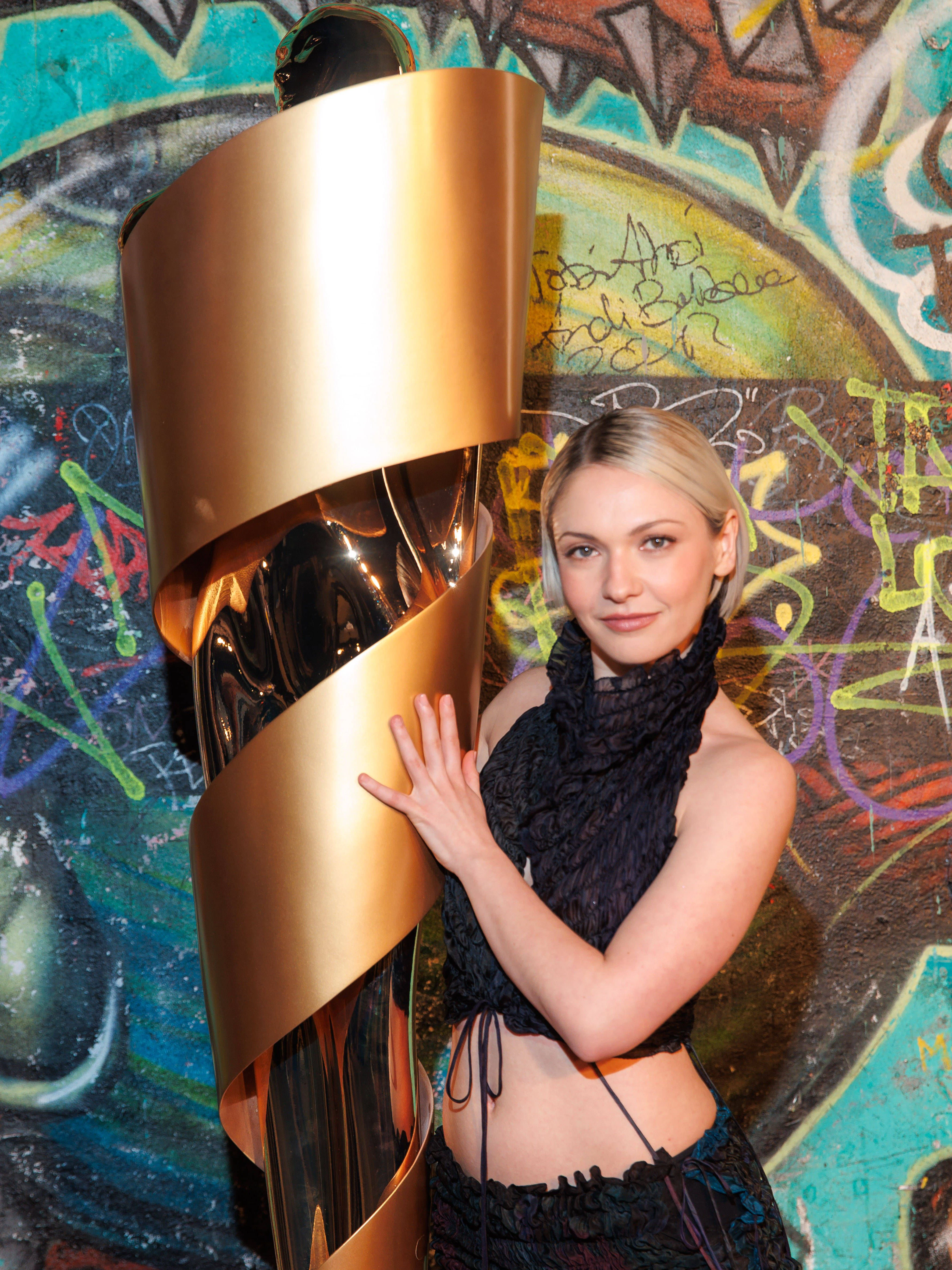 Die Schauspielerin Emma Nova lehnt sich beim Nominiertenabend an eine Riesen-Lola an.