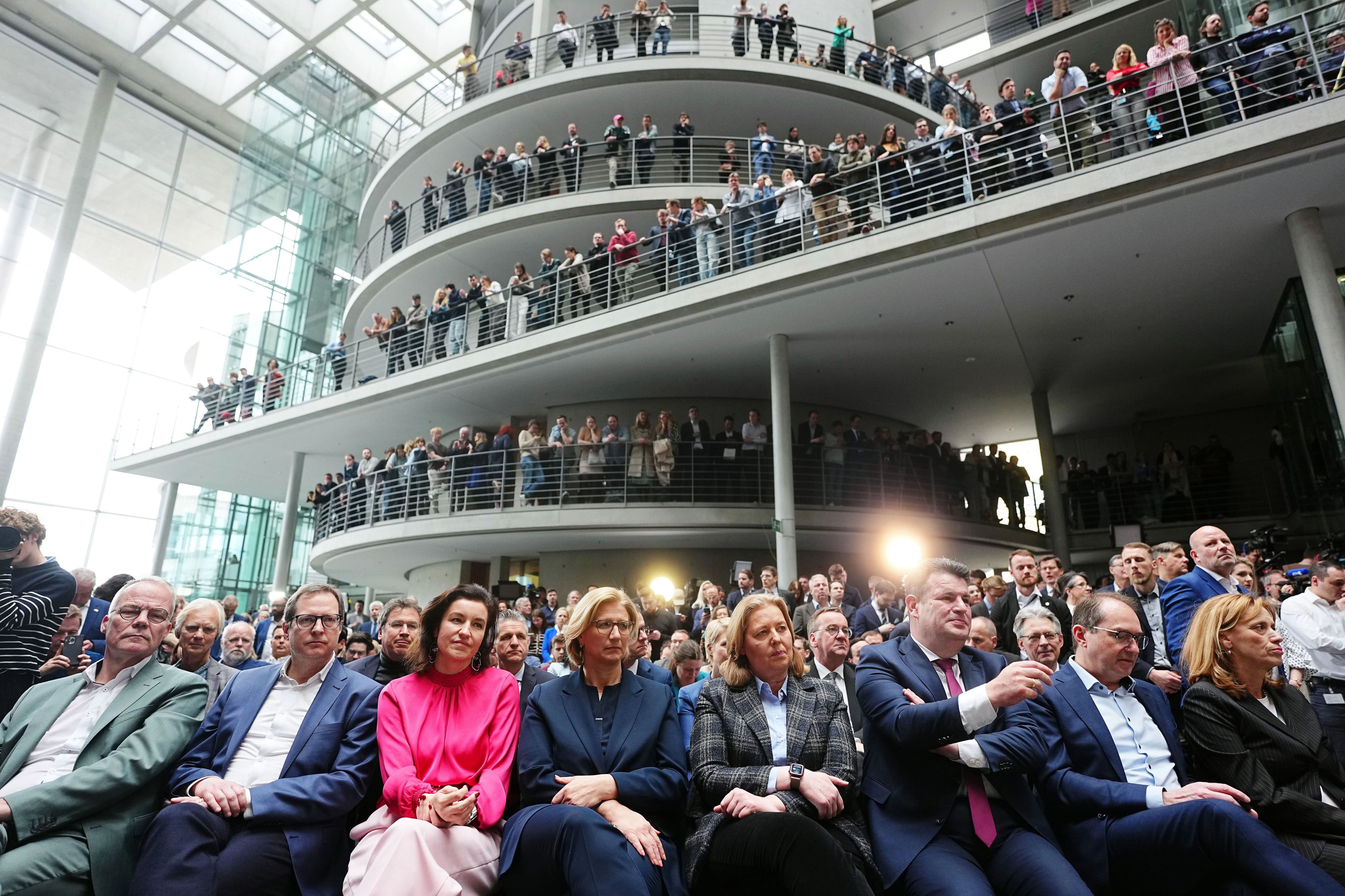 Viele verfolgen die Pressekonferenz von den offenen Etagen des Foyers aus.