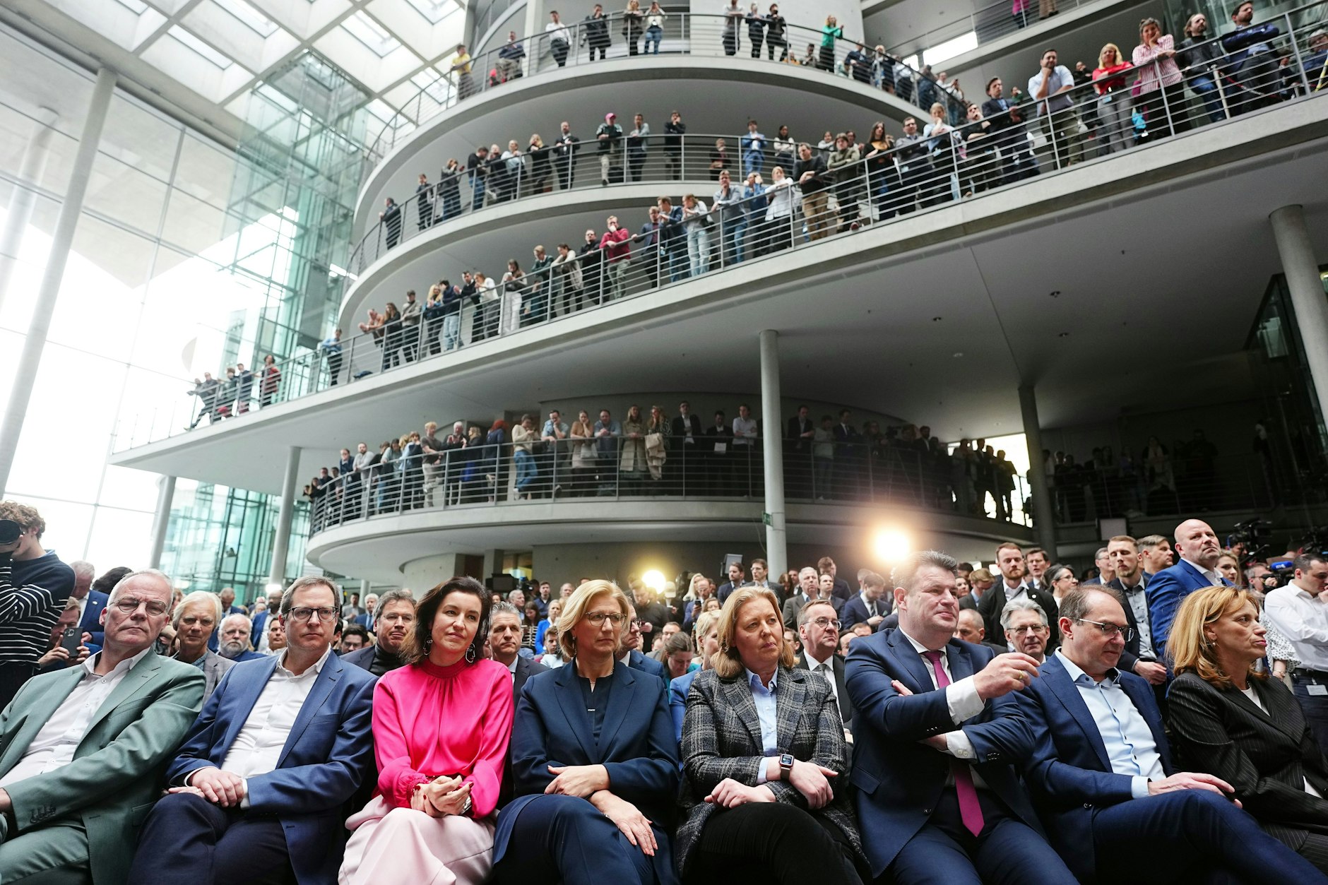 Viele verfolgen die Pressekonferenz von den offenen Etagen des Foyers aus.