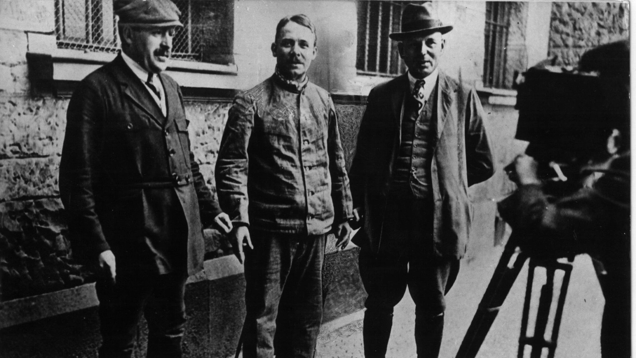 Fritz Haarmann (Mitte) wird von Kriminalbeamten in Handschellen gehalten und gefilmt.