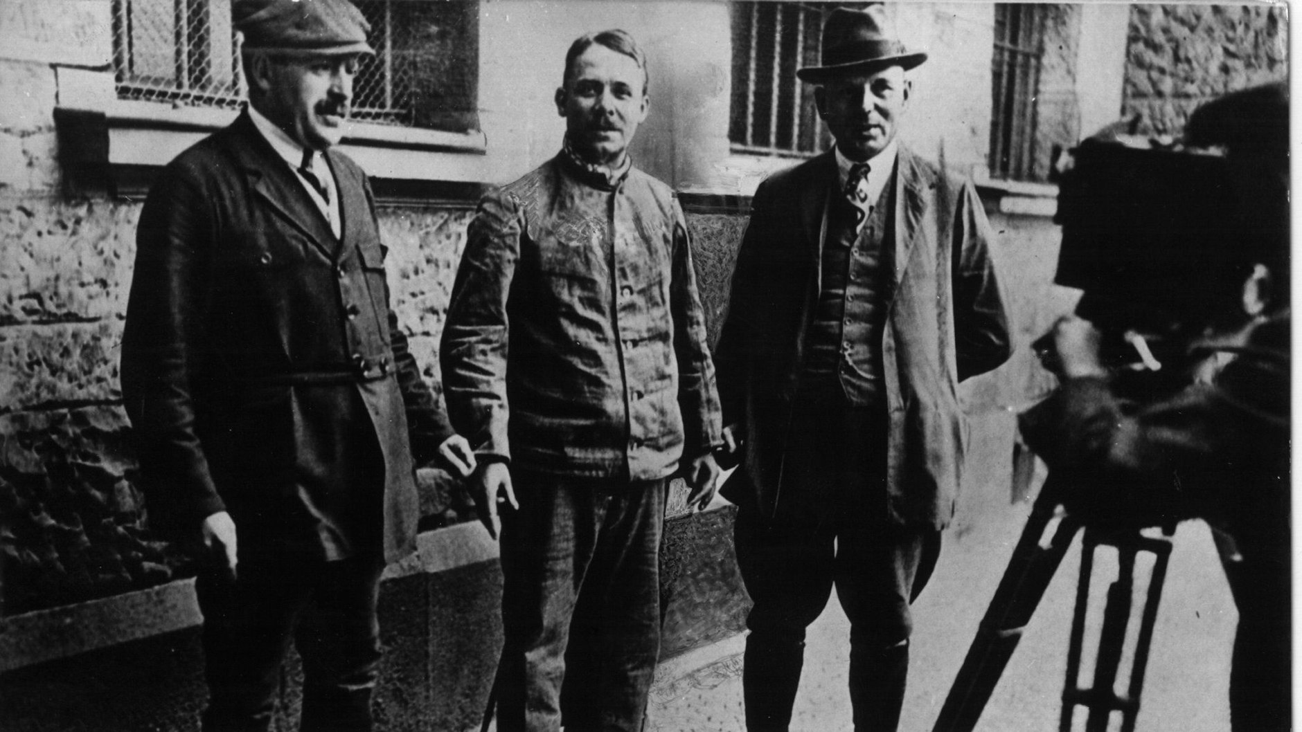 Fritz Haarmann (Mitte) wird von Kriminalbeamten in Handschellen gehalten und gefilmt.