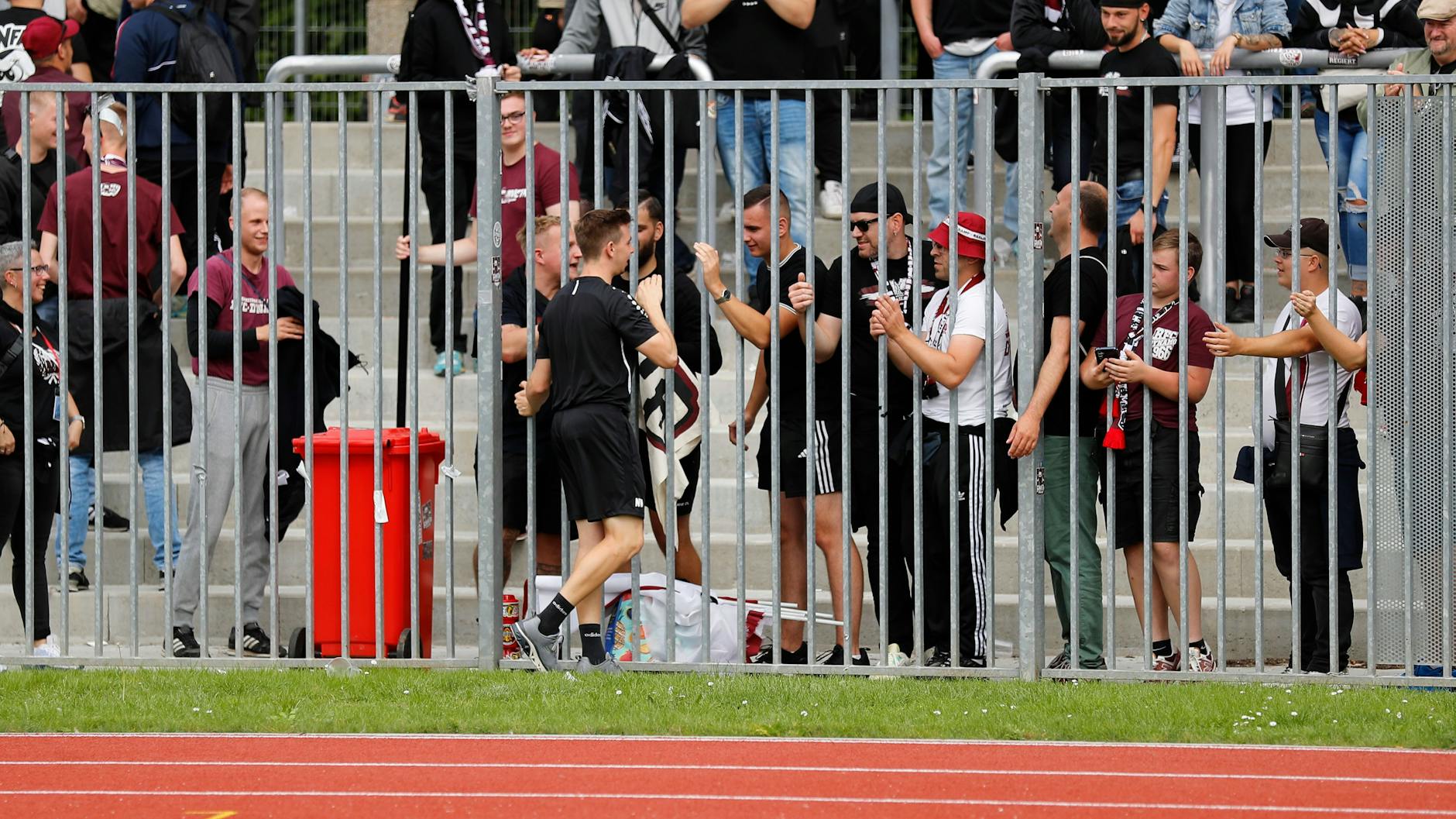 Nachdem er als Interimstrainer mit dem BFC Dynamo ein starkes 0:0 in Greifswald holt, feiern die Fans Nils Weiler am Zaun.