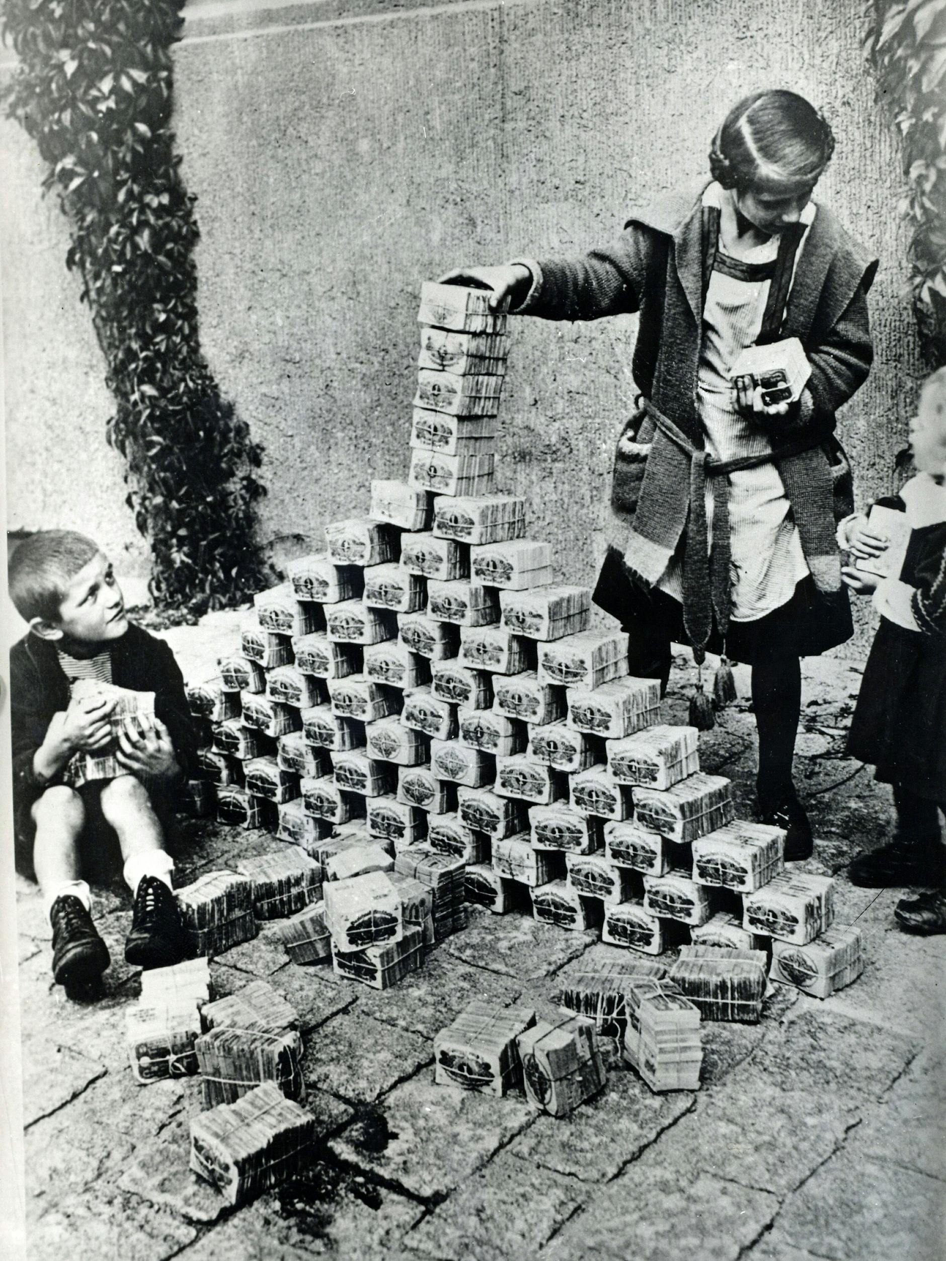 Kinder spielen während der Hyperinflation 1923 mit Bündeln von Geldscheinen