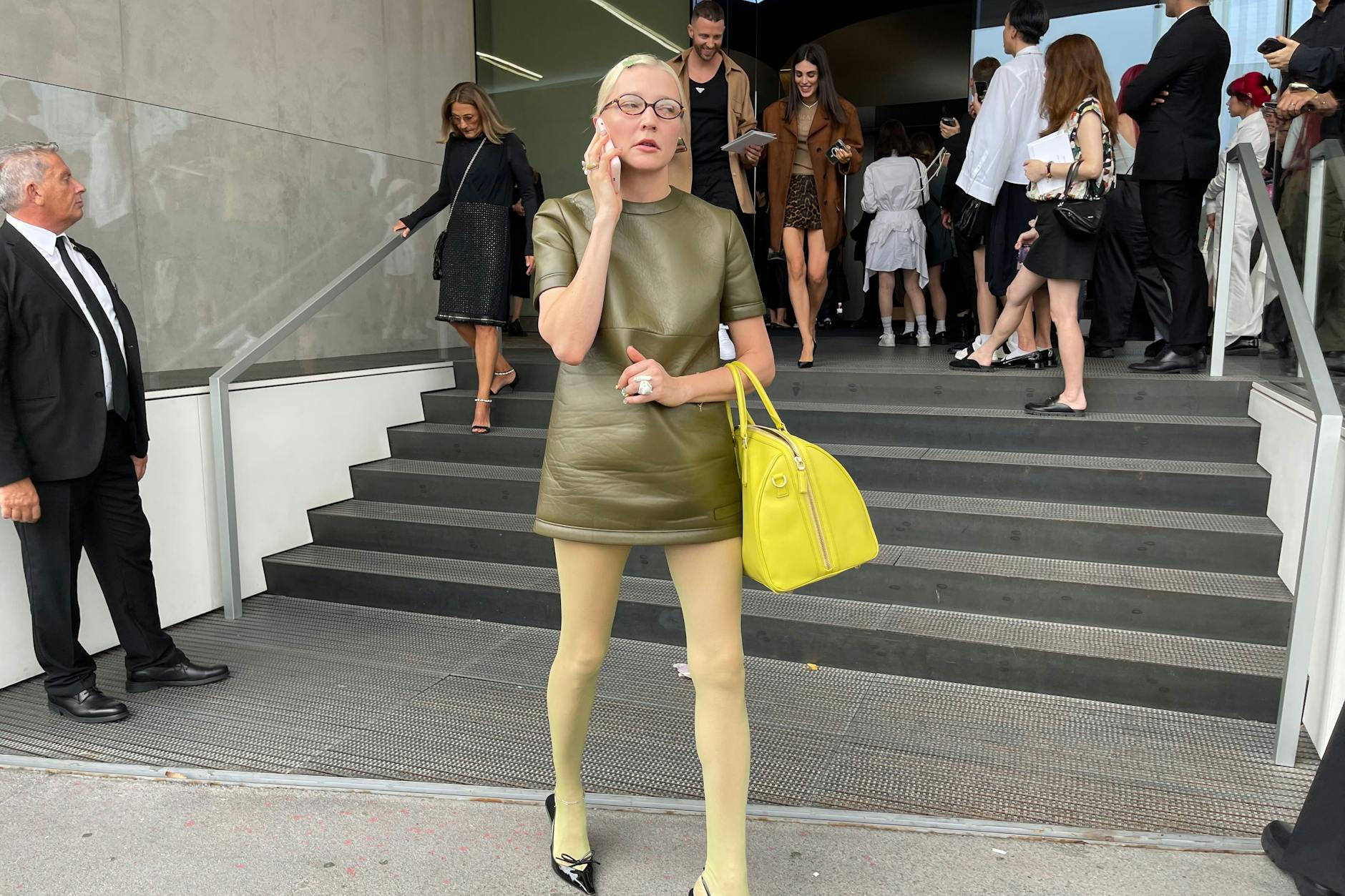 Schon wieder am Telefon: Lotta Volkova mit Lederkleid und Brille von Miu Miu, Schuhe und die Tasche sind von Prada.