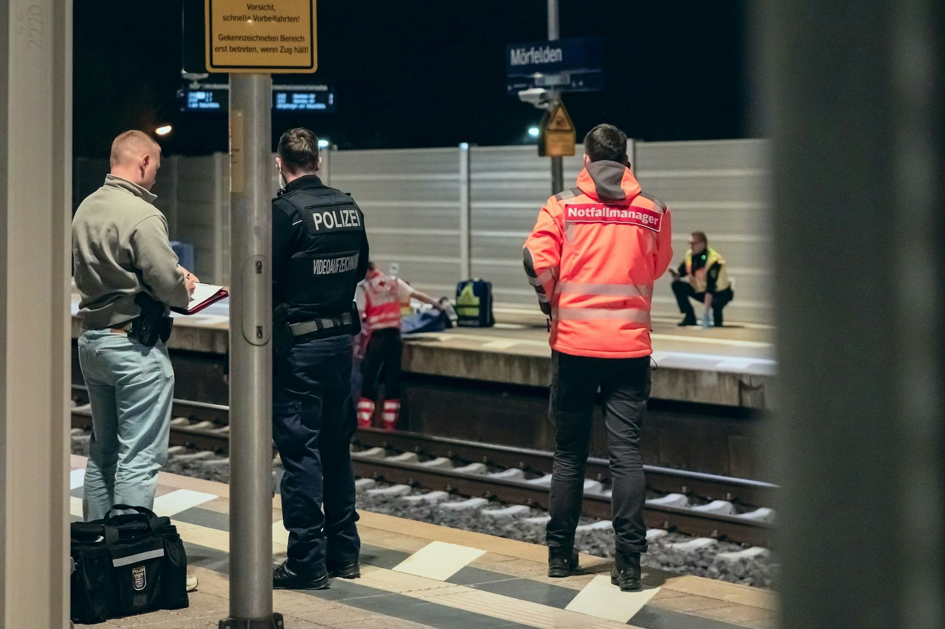 Retter arbeiten am Bahnsteig des Bahnhofs in Mörfelden. Ein Mann ist von einem vorbeifahrenden Güterzug seitlich erfasst und dabei tödlich verletzt worden. Er sei zwischen dem Bahnsteig und den Gleisen liegen geblieben.
