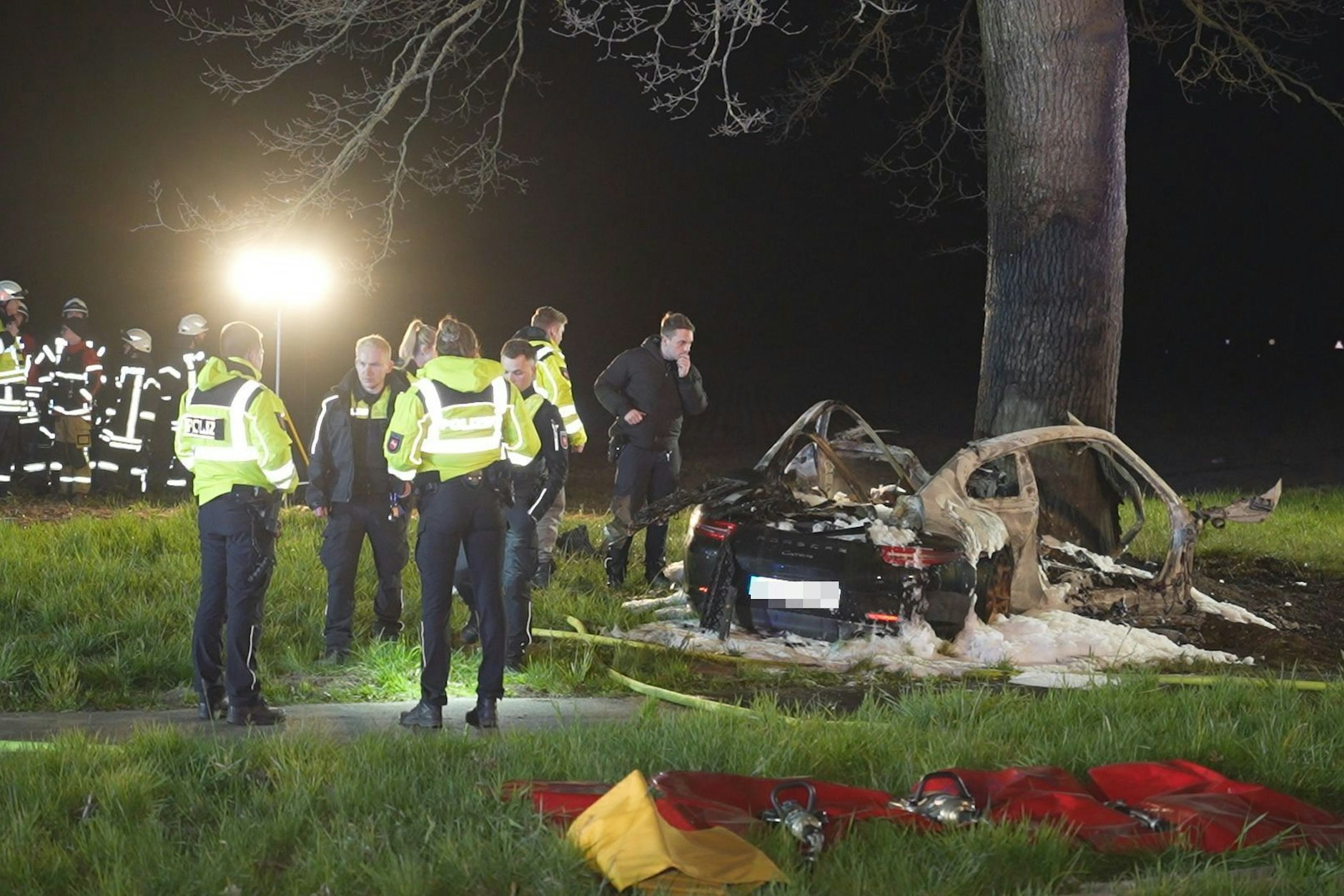 Einsatzkräfte an er Unfallstelle in Syke (Niedersachsen). In dem Porsche waren zwei 17-Jährige unterwegs. Der Sportwagen krachte gegen einen Baum, ging in Flammen auf.