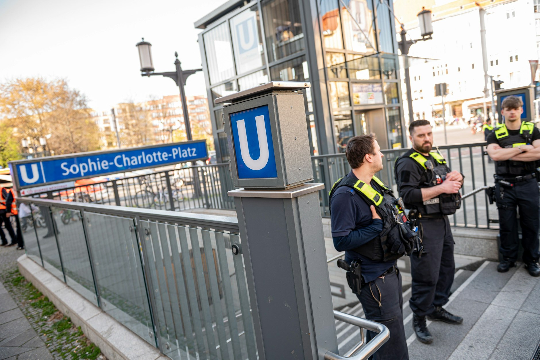 Berliner Polizisten stehen nach einer Gewalttat am U-Bahnhof Sophie-Charlotte-Platz zusammen. Angreifer und Opfer sind tot.
