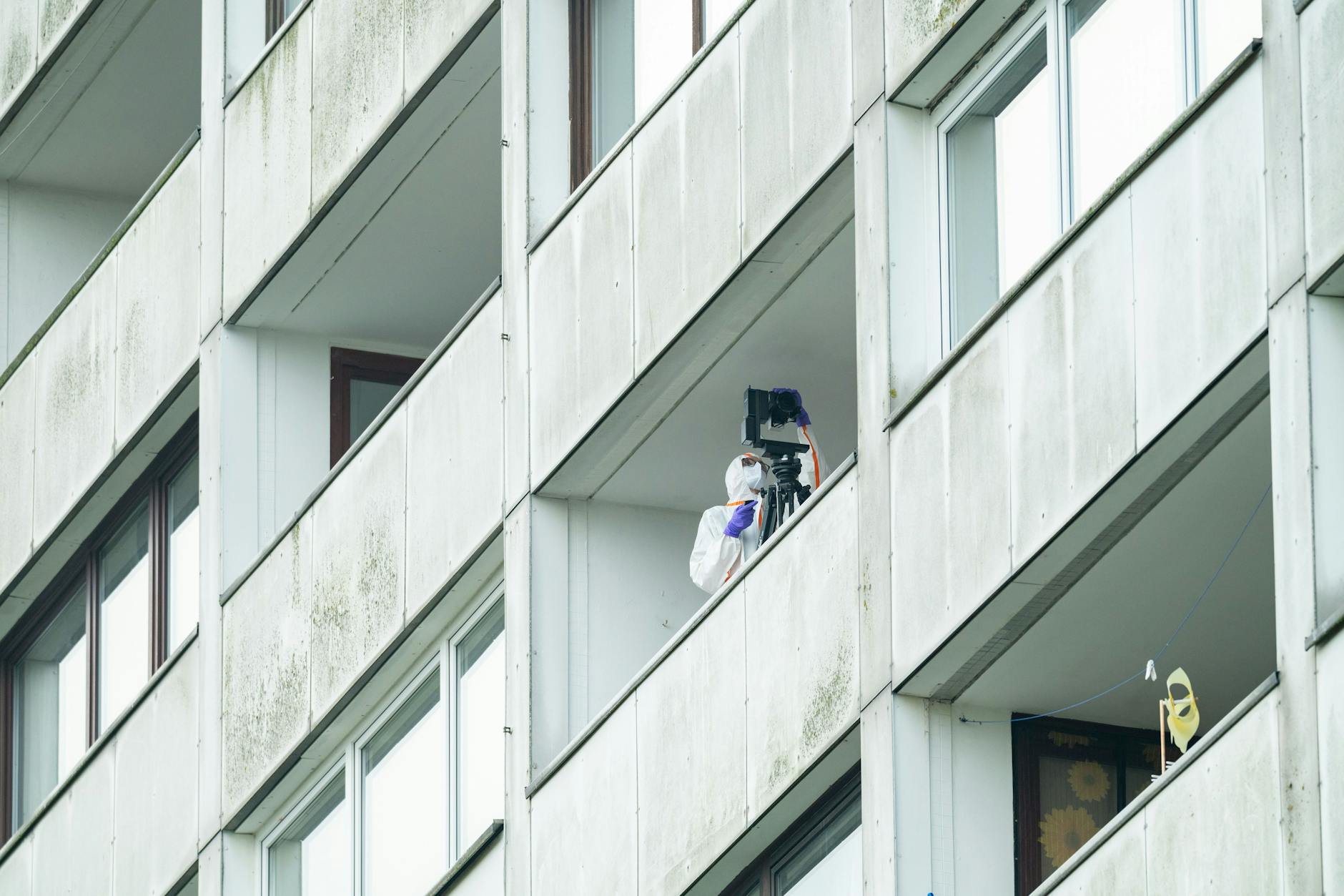 Beamte der Spurensicherung ermitteln auf einem Balkon des Hochhauses. Ein junger Mann ist in der Nacht in Hamburg-Wilsdorf vom Balkon eines Hochhauses in den Tod gestürzt.