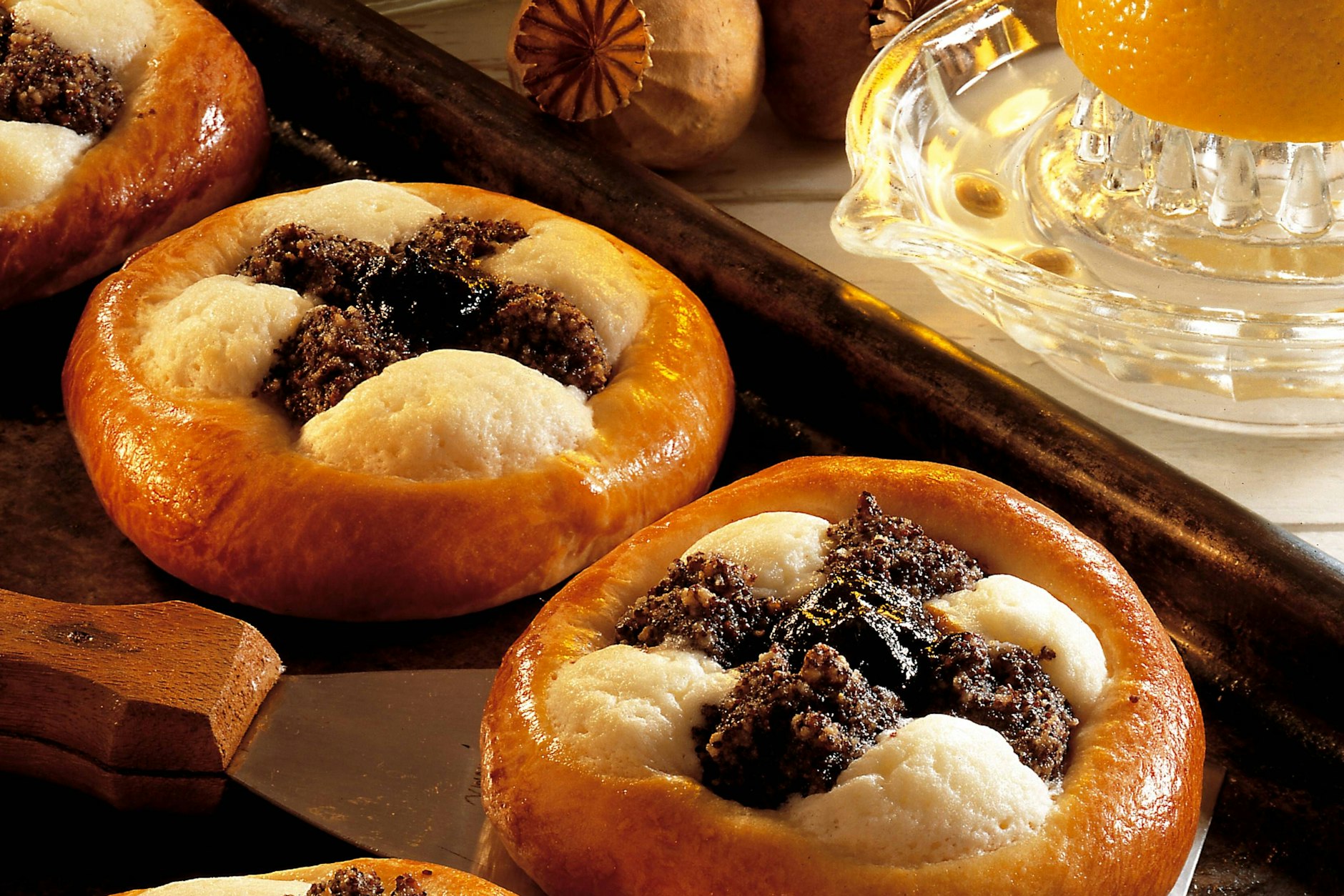 Kreisrund, mit einem Kreuz verziert: So sehen Kolatschen aus. Es gibt zwei besonders beliebte Beläge. Mit Pflaumenmus oder wie hier im Foto mit Quark und Mohn.