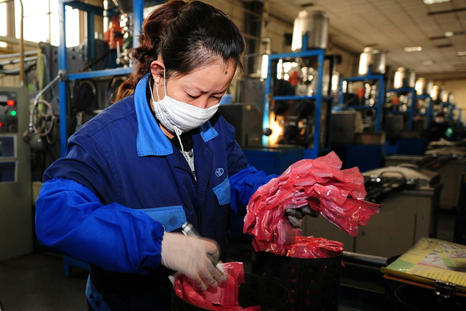 Eine chinesische Arbeiterin verpackt aus seltenen Erden bestehende Halbfertigprodukte.