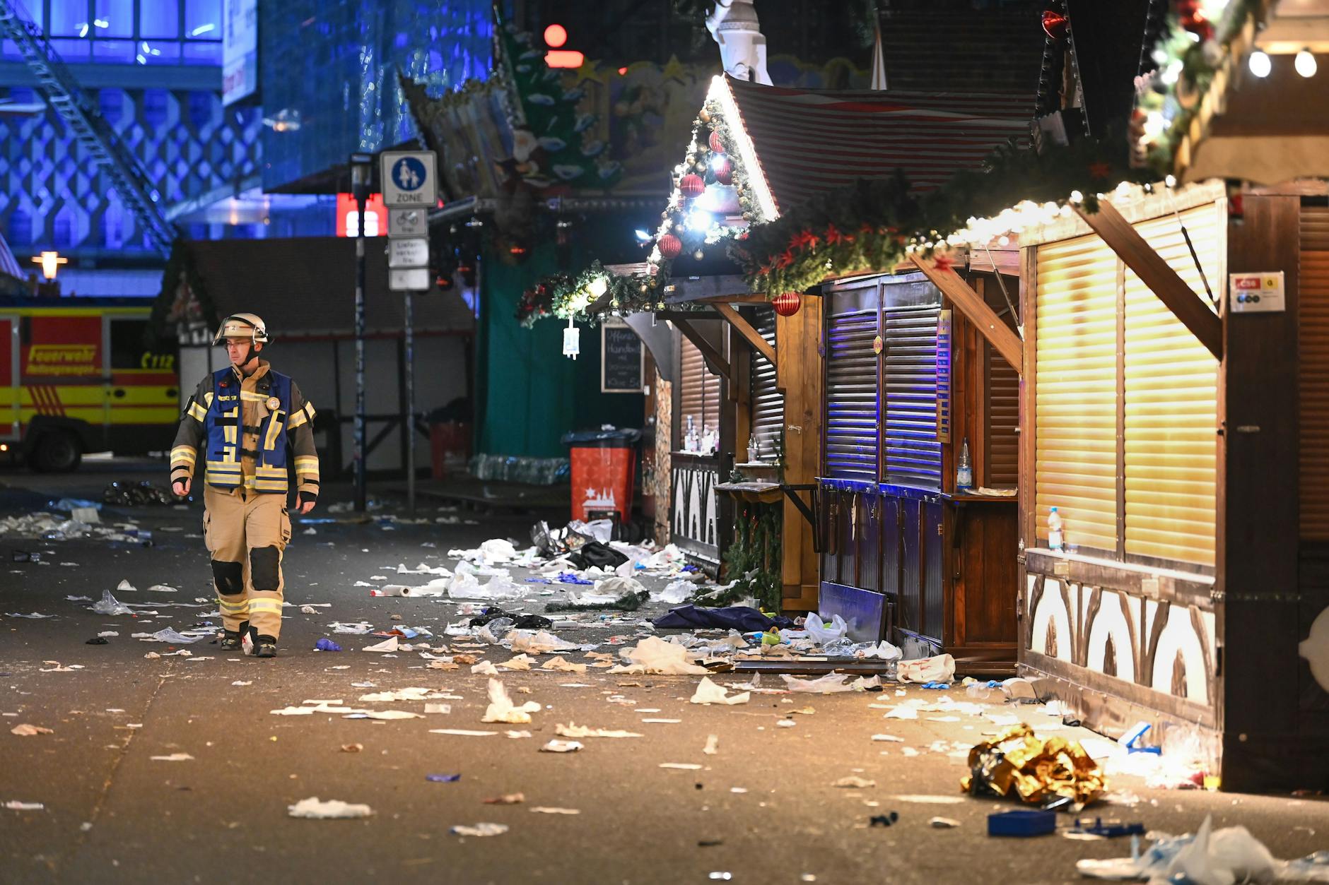 Ein Feuerwehrmann läuft über den verwüsteten Weihnachtsmarkt auf dem Alten Markt.