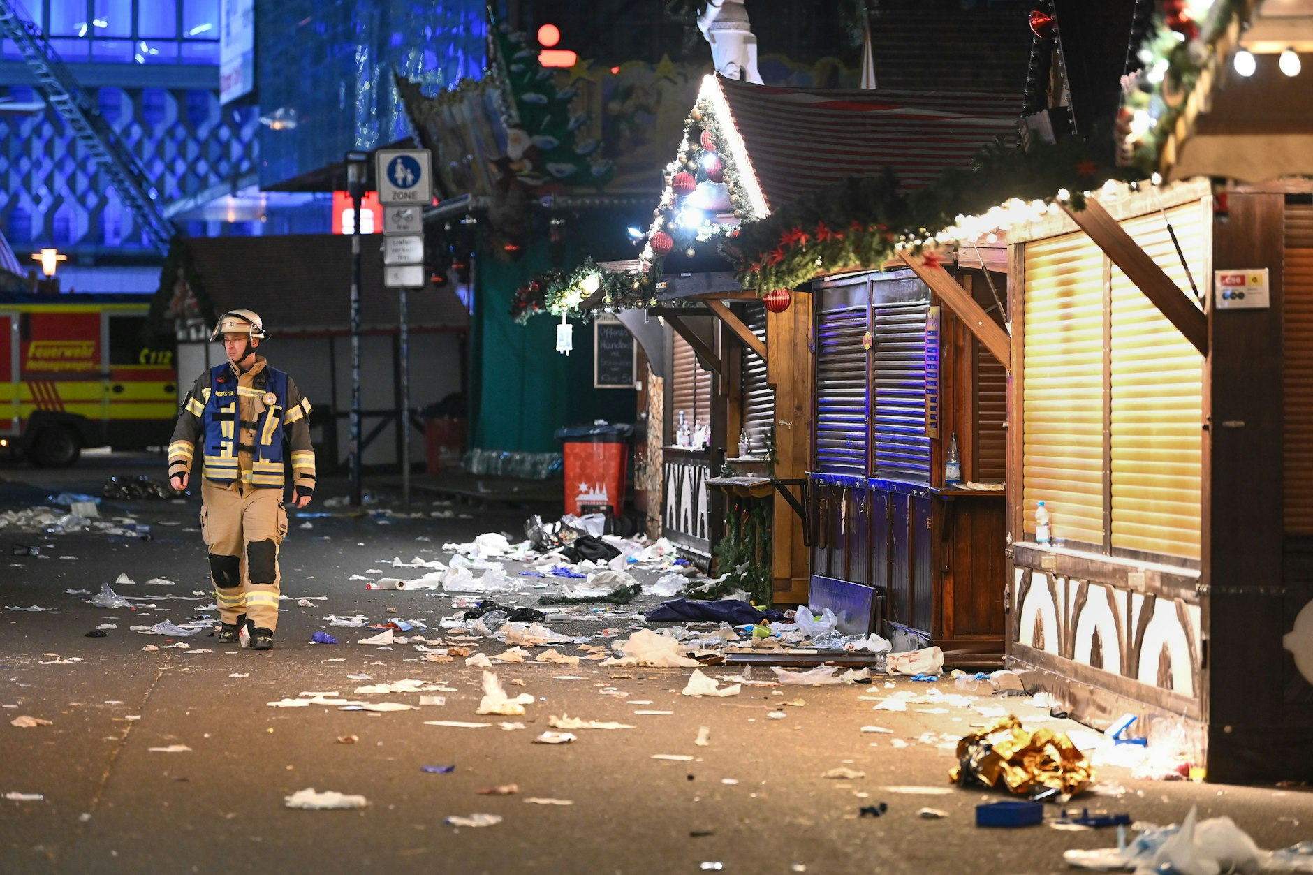 Ein Feuerwehrmann läuft über den verwüsteten Weihnachtsmarkt auf dem Alten Markt.