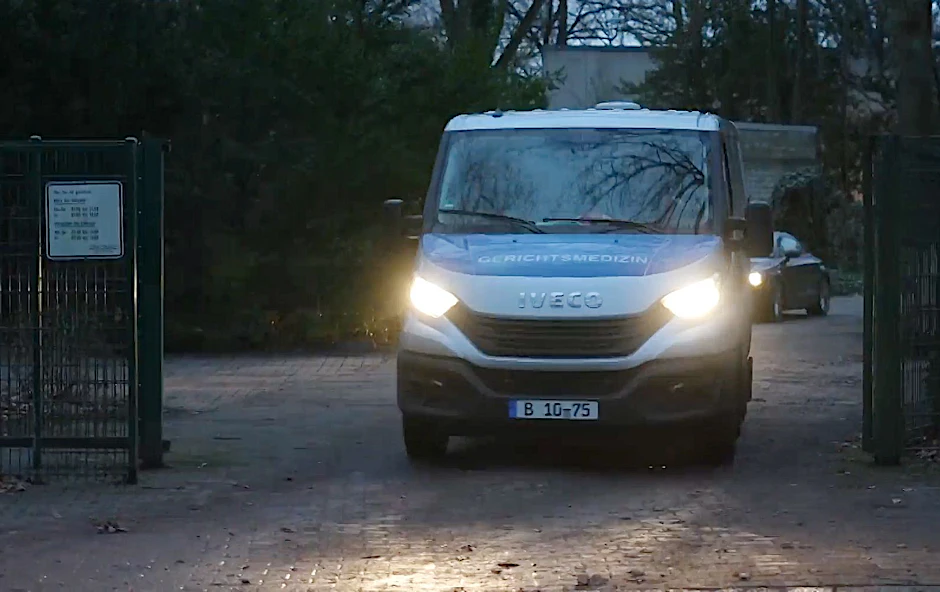 Ein Auto der Gerichtsmedizin verlässt einen Tatort.