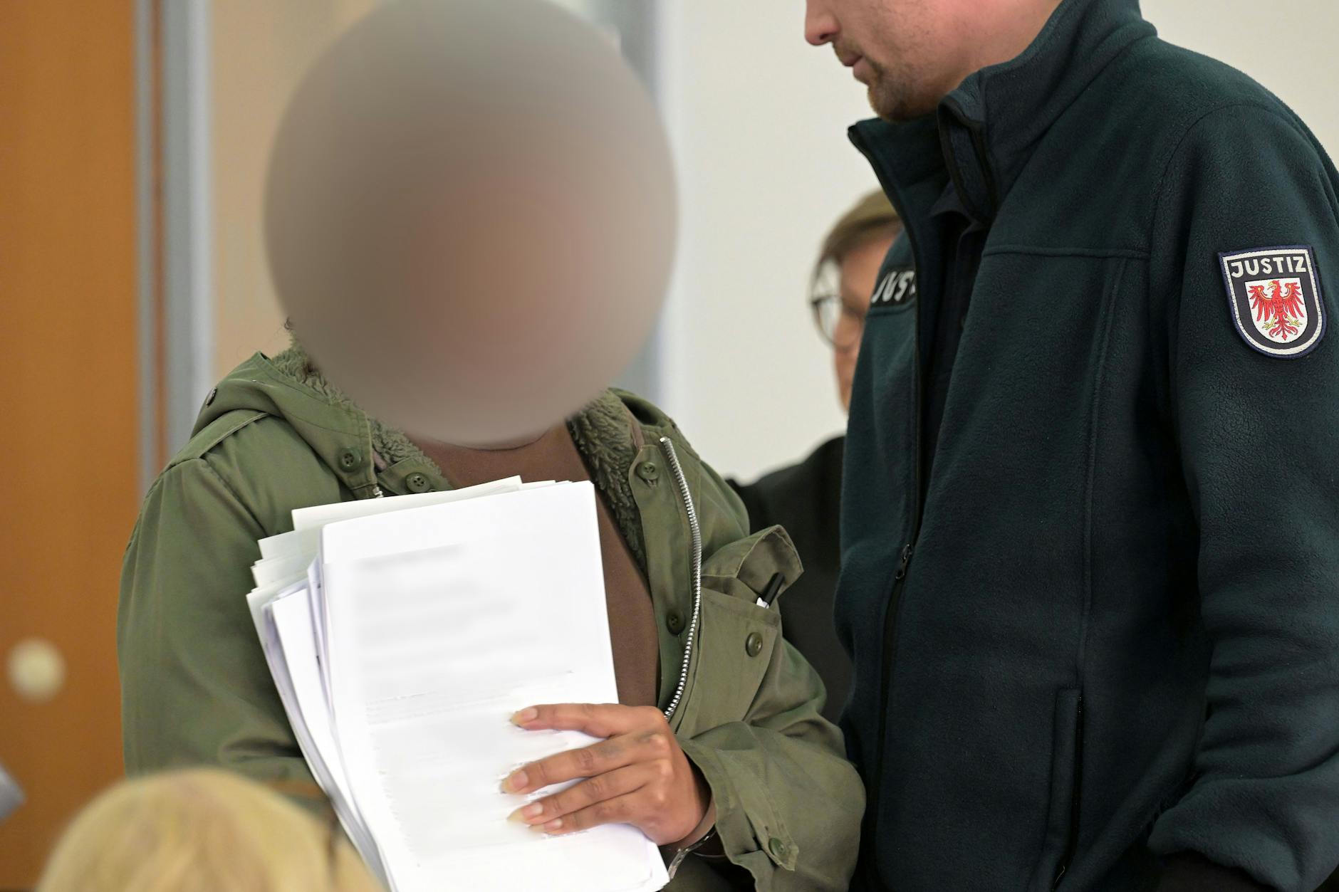 Die angeklagte Frau betritt den Verhandlungssaal im Landgericht beim Prozessauftakt wegen eines tödlichen Angriffs auf einen Wachmann.