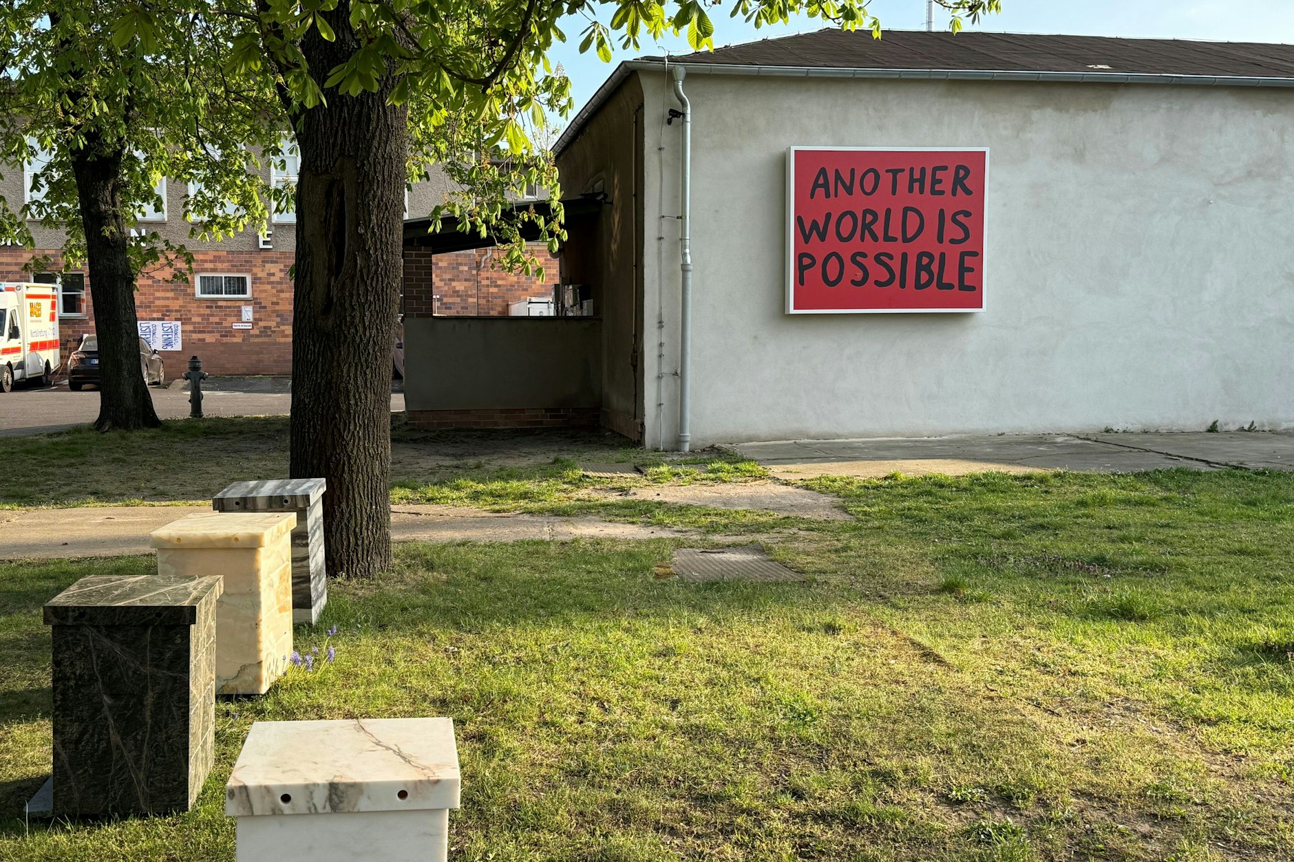 Sam Durants ermutigender Leitgedanke an der Wand und links davor die marmornen „Bienentod-Memorials“ von Ana Prvacki
