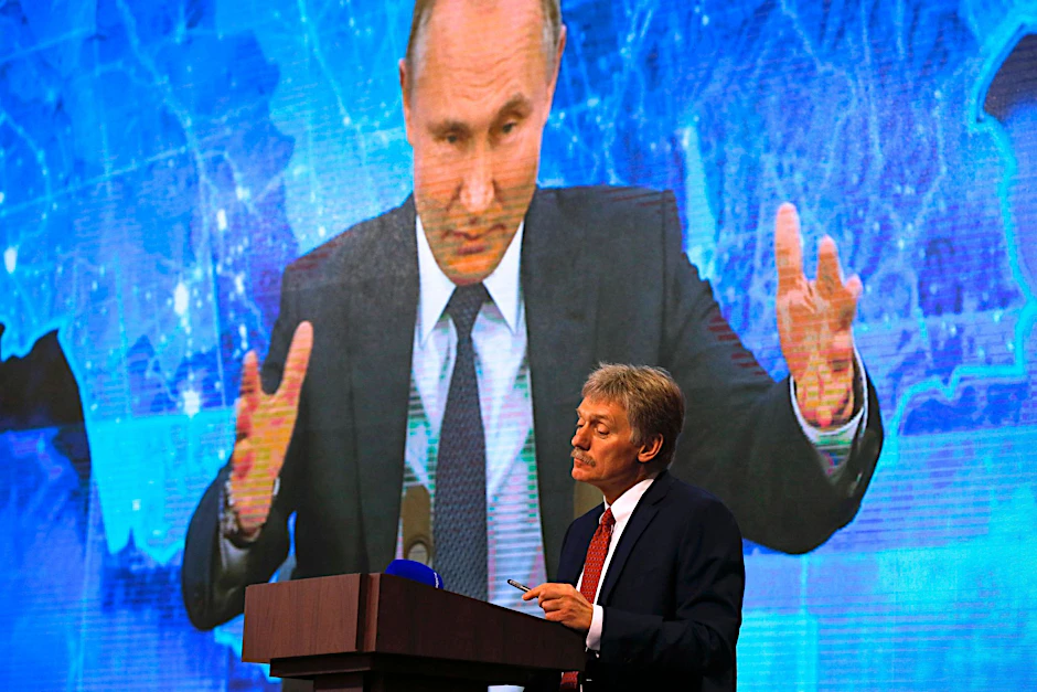 ARCHIV - Wladimir Putin spricht bei einer Pressekonferenz per Video zu Medienvertretern, Kremlsprecher Dmitri Peskow hört zu.