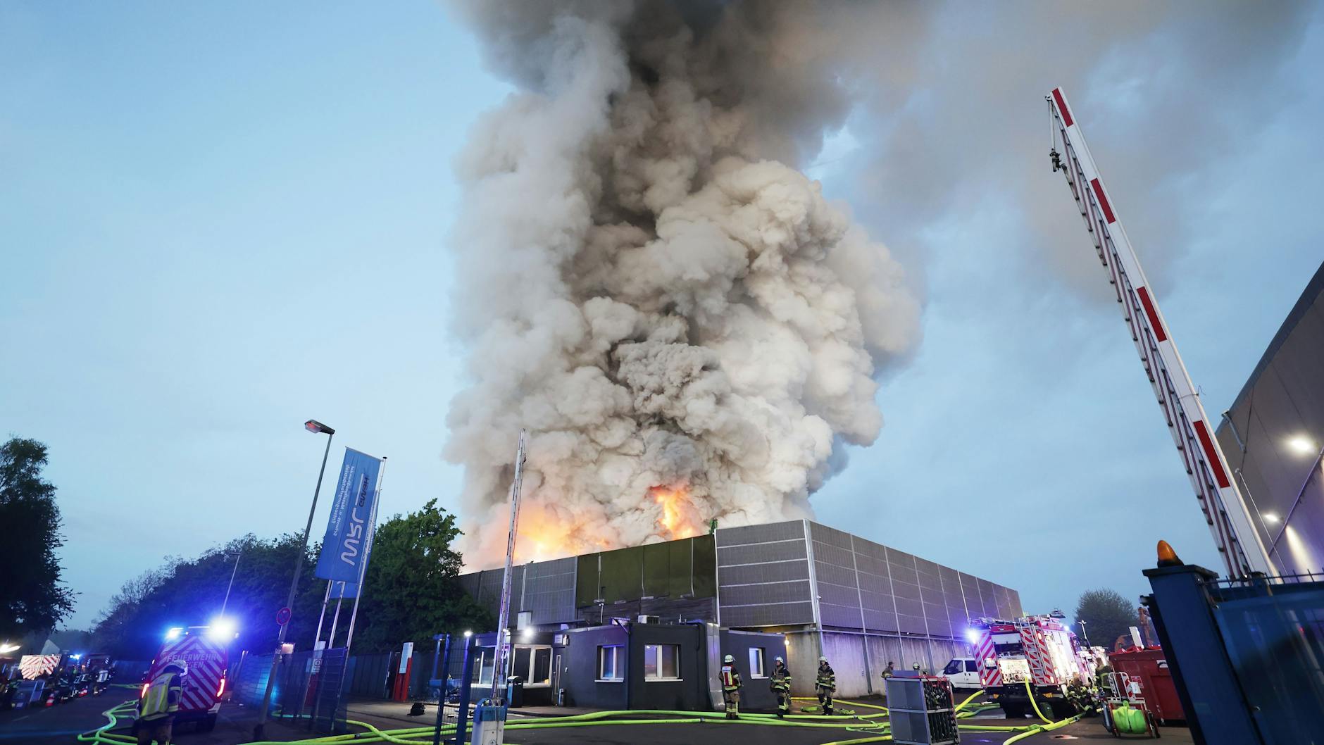 Die Feuerwehr in Essen bekämpft einen Großbrand. Flammen steigen aus dem brennenden Schrottberg.