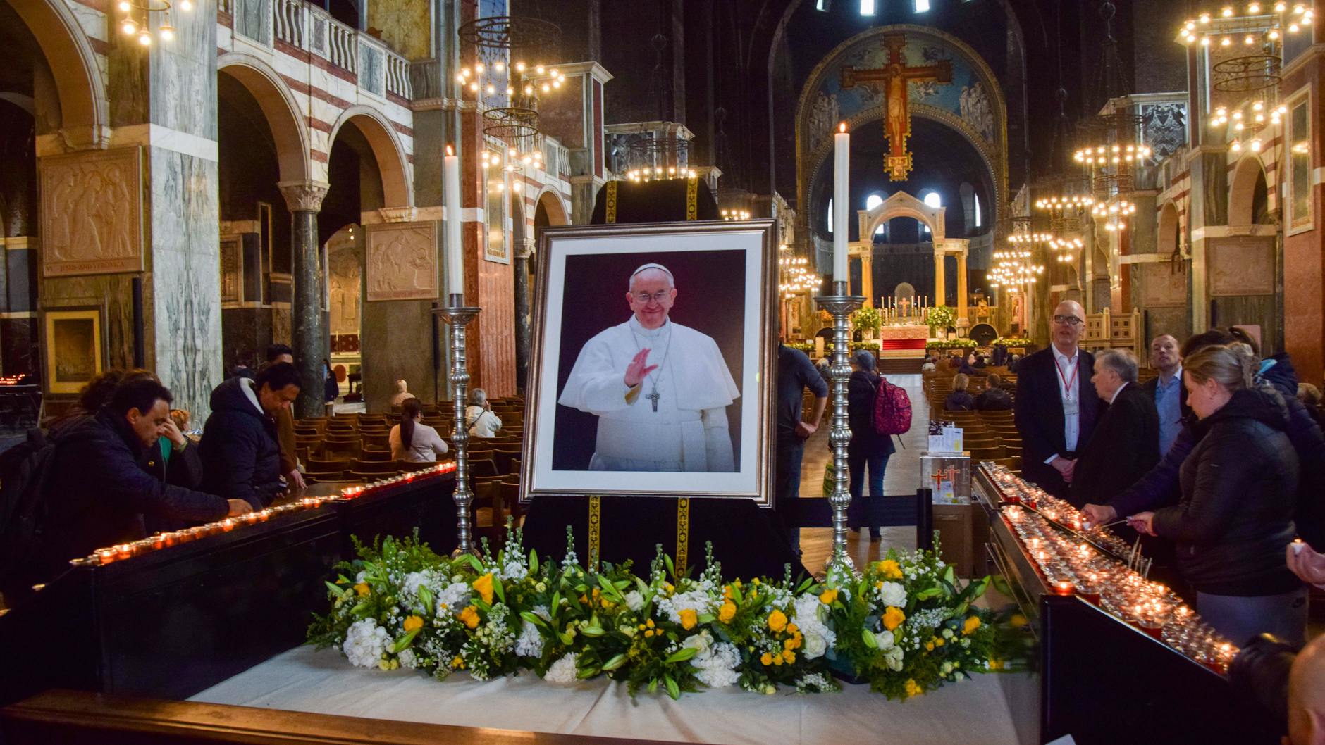 Auf der ganzen Welt wird im Papst Franziskus getrauert. Hier: Blumen, Kerzen und ein Porträt des Kirchenoberhauptes in der Kathedrale von Westminster in London.