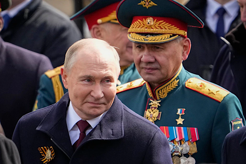 Der russische Präsident Wladimir Putin (l) und der russische Verteidigungsminister Sergei Schoigu (r) verlassen den Roten Platz nach der Militärparade zum Tag des Sieges.