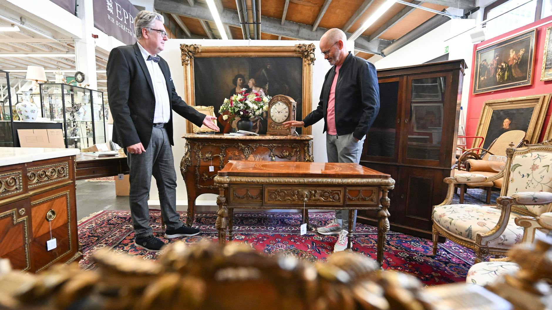 Der Auktionator Rene Waldrab (l.) und der Antiquitätenexperte Jose Juan Martinez-Garcia stehen im Auktionshaus Eppli bei antiken Möbeln des Entertainers Harald Juhnke.