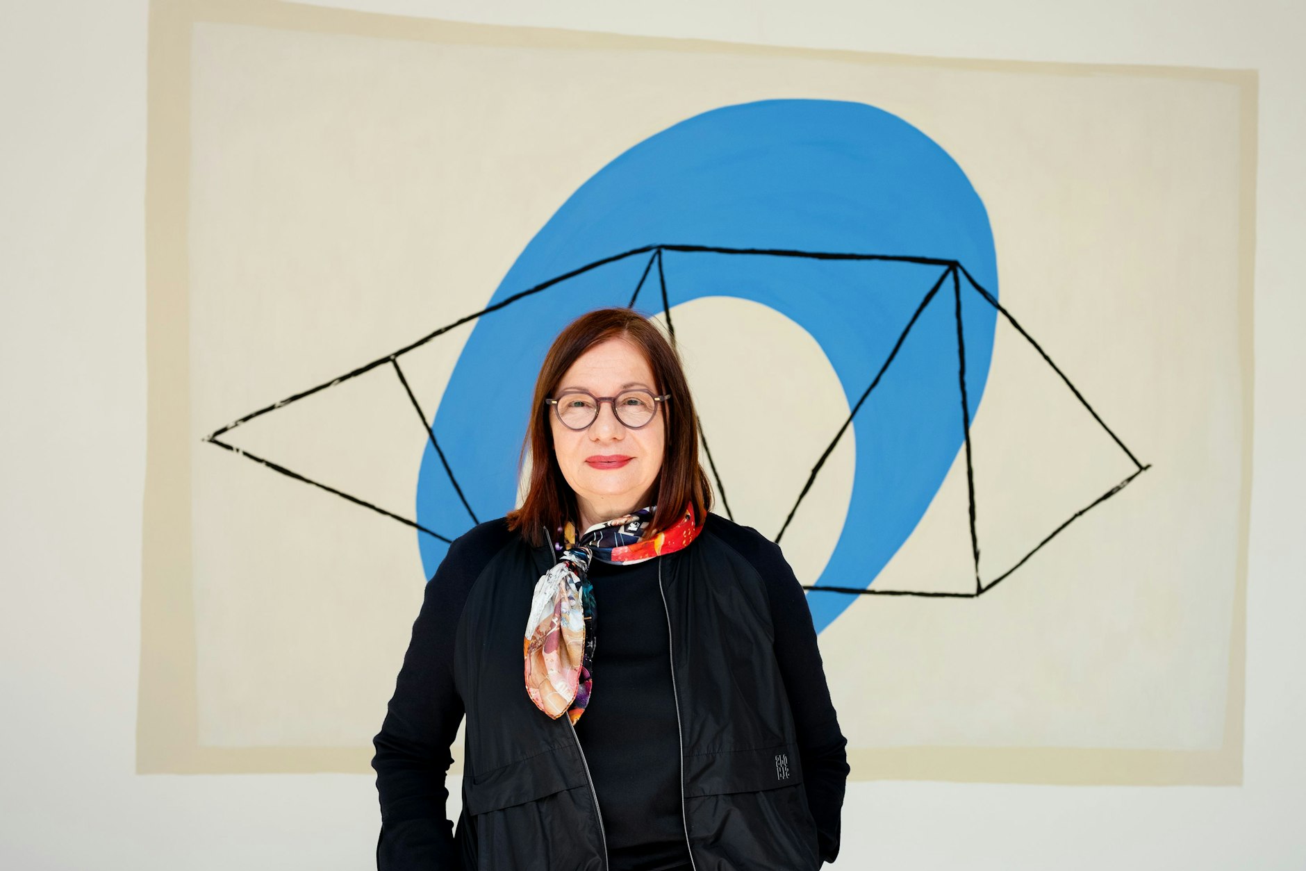 Wita Noack im Mies-van-der-Rohe-Haus, hinter ihr das Leitbild der Max-Bill-Ausstellung: Entwurf für ein „Wandbild mit großem O“