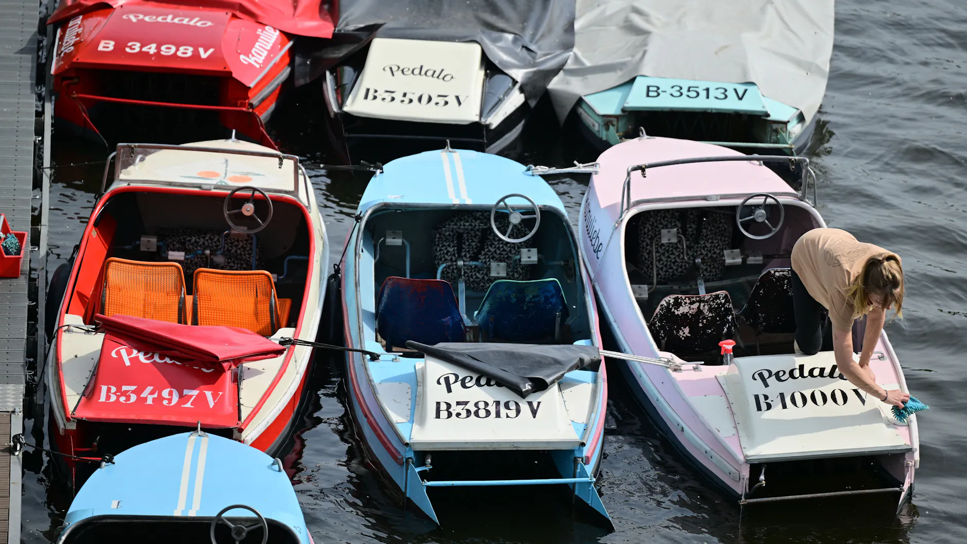 Mitarbeiterin Laura bereitet beim Bootsverleih Kanuliebe Tretboote vor.