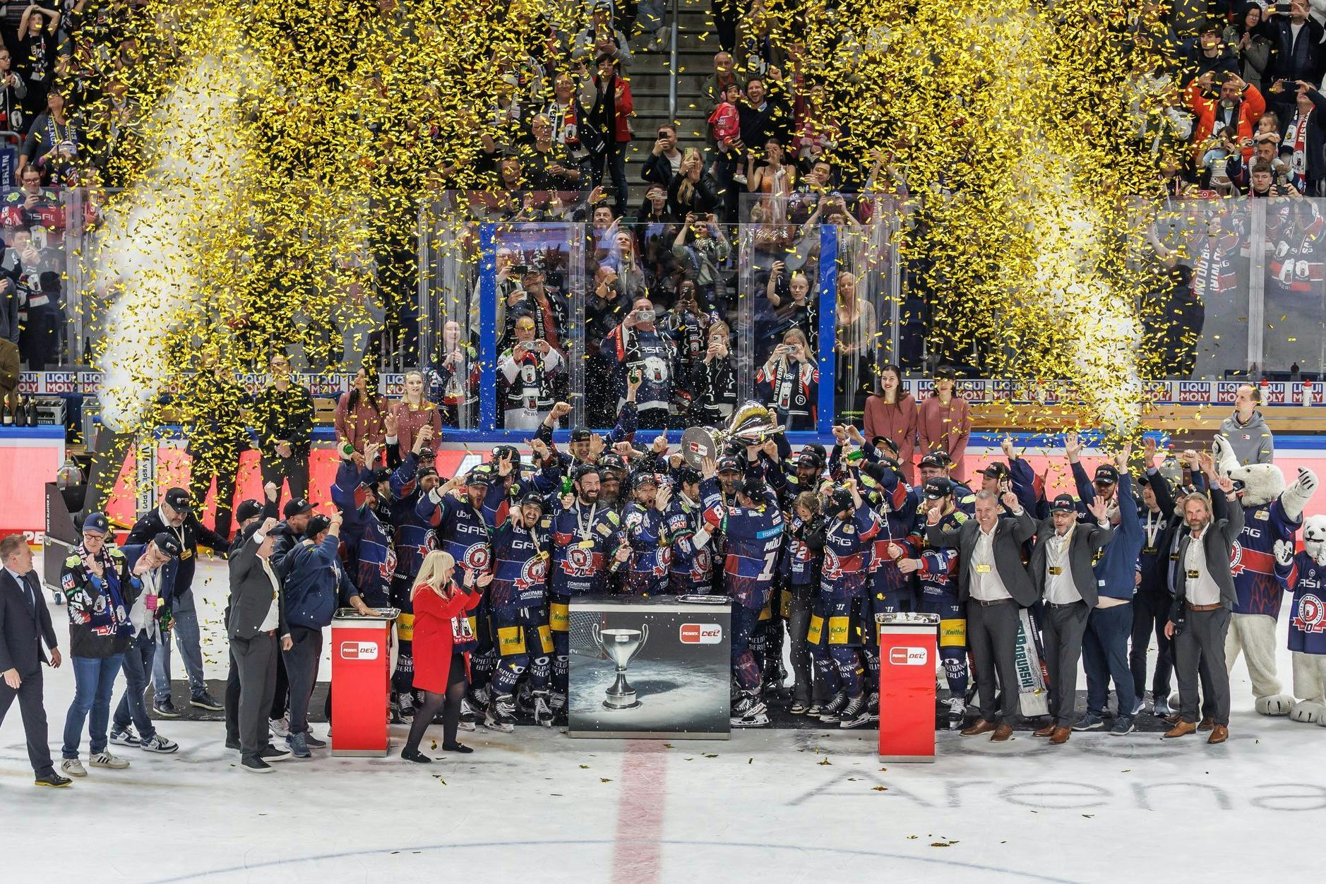 Die Spieler der Eisbären Berlin jubeln mit Medaillen und Pokal bei der Siegerehrung zum Deutschen Meister.