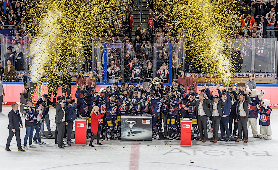 Die Spieler der Eisbären Berlin jubeln mit Medaillen und Pokal bei der Siegerehrung zum Deutschen Meister.