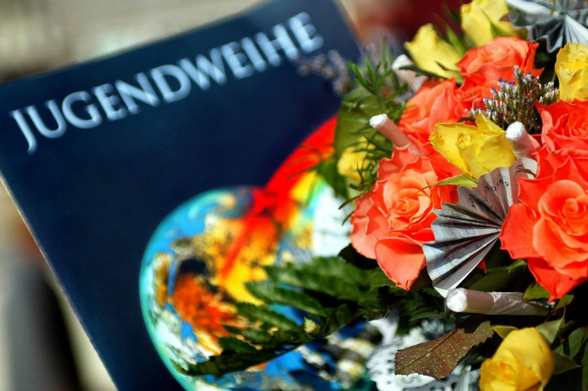Eine Jugendweihe-Urkunde liegt neben einem Blumenstrauß: Die Jugendweihefeiern starten wieder - vor allem im Osten Deutschlands.