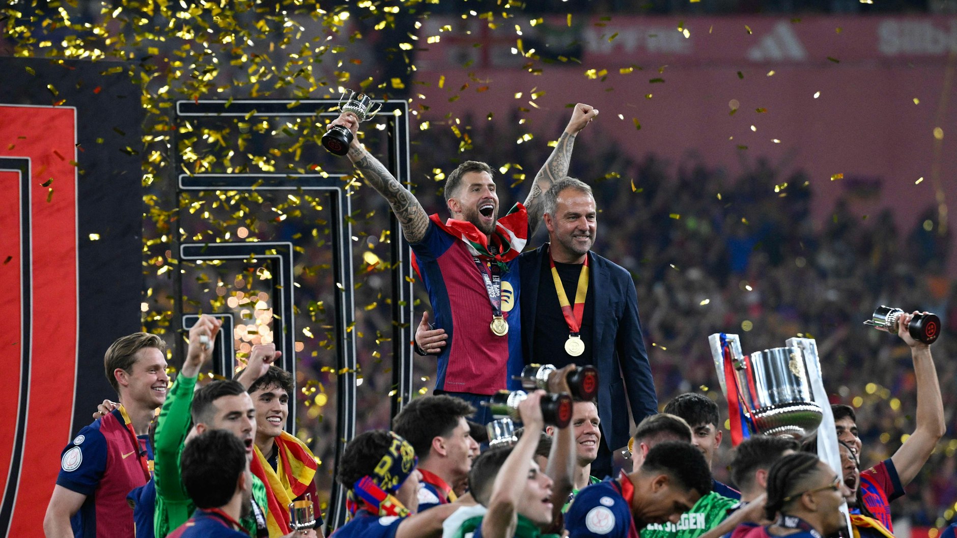 Hansi Flick mitten in der Jubeltraube seiner Spieler vom FC Barcelona nach dem Gewinn des spanischen Pokals.