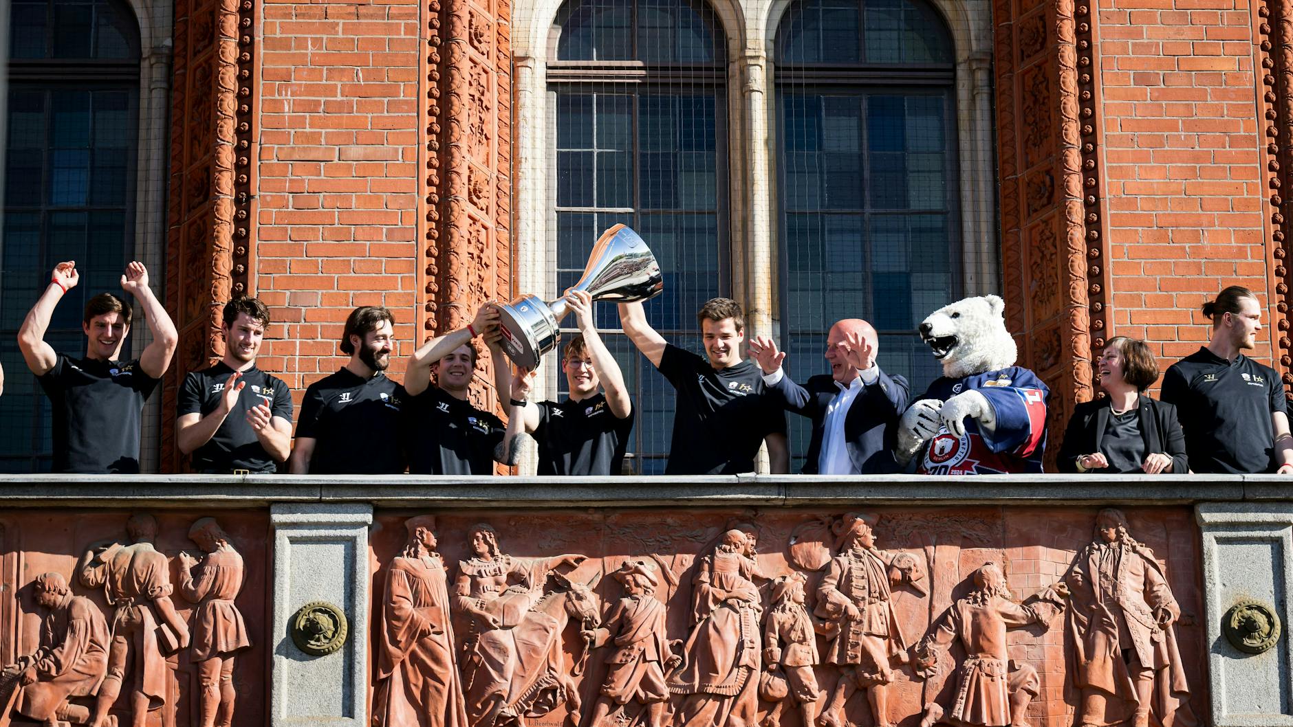 Als die Eisbären den Meisterpott auf dem Balkon des Roten Rathauses präsentieren, sind die Henkel ab.