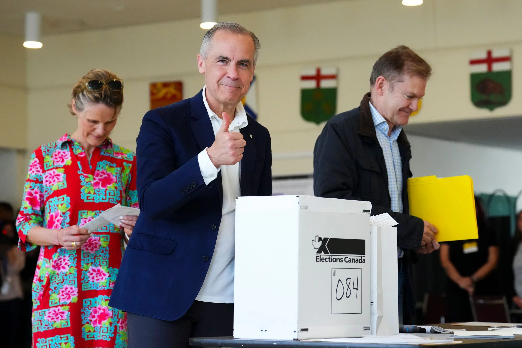 Kanadas Premierminister Mark Carney gibt zusammen mit seiner Frau Diana Fox Carney in einem Wahllokal seine Stimme für die Parlamentswahl ab.