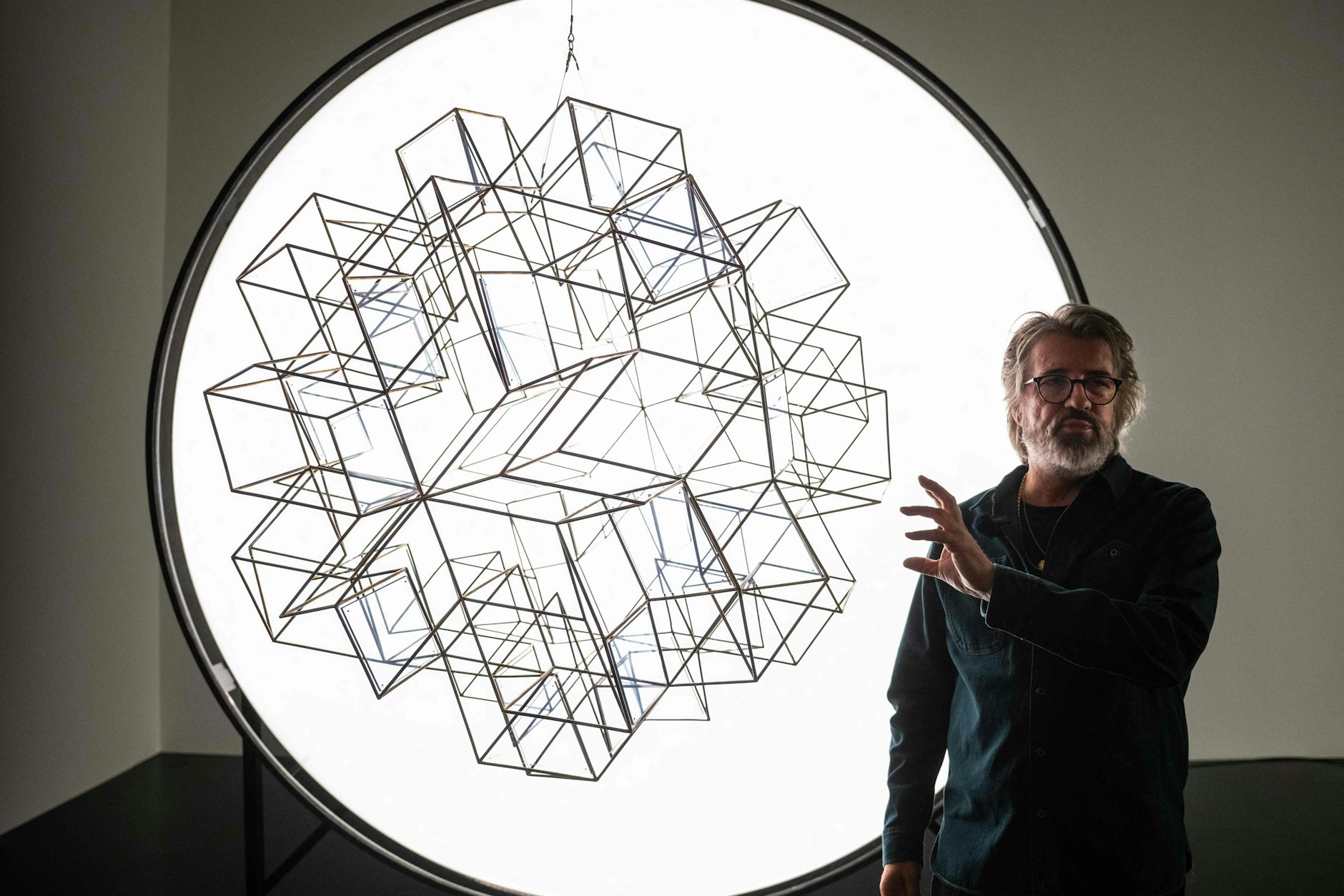 Ólafur Elíasson in der Ausstellungshalle mit Polarisationsfilter und geometrischem Raumobjekt, das im nächsten Augenblick durch Lichteinfall als Farbspiel erscheinen wird