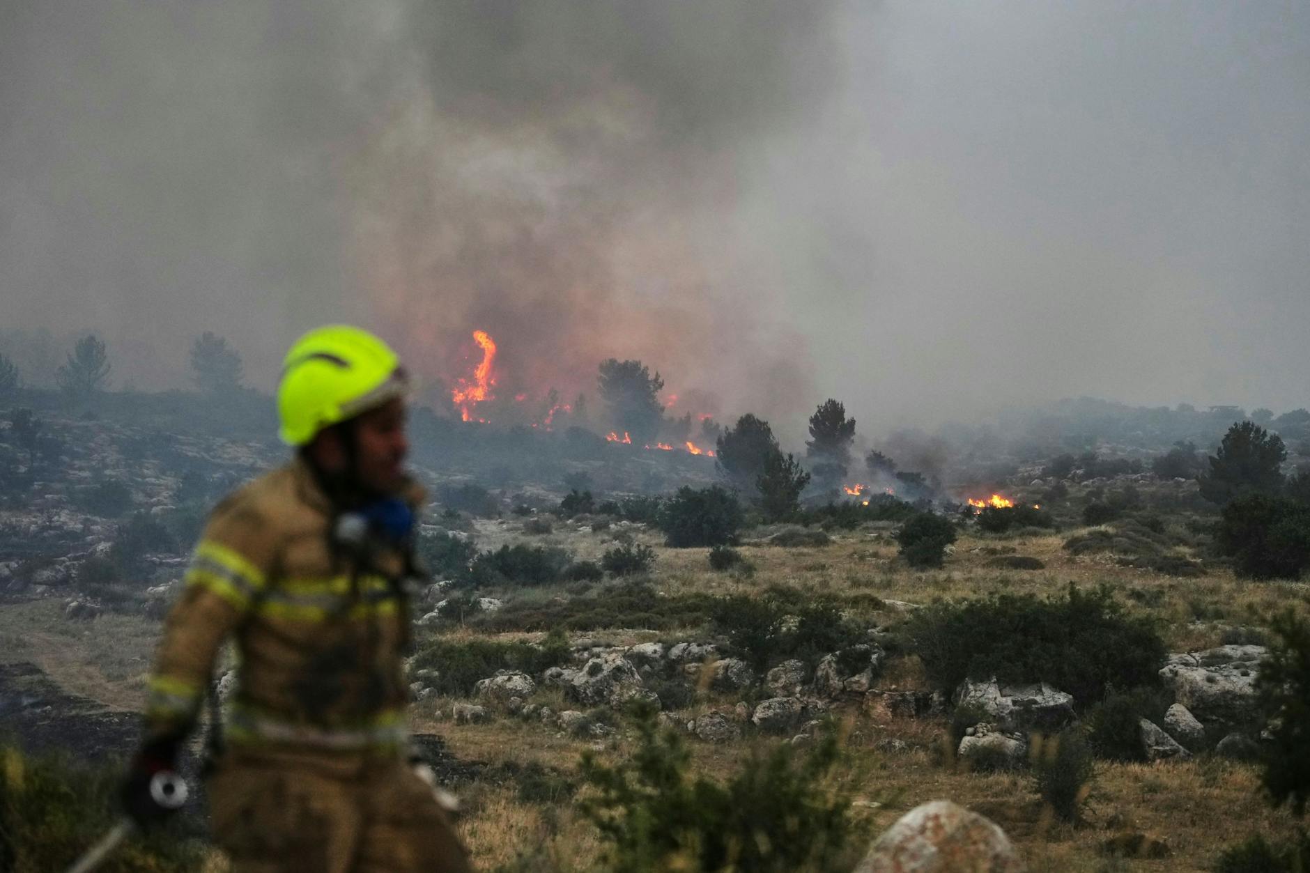 Ein israelischer Feuerwehrmann arbeitet bei einem Waldbrand in der Nähe von Latrun.