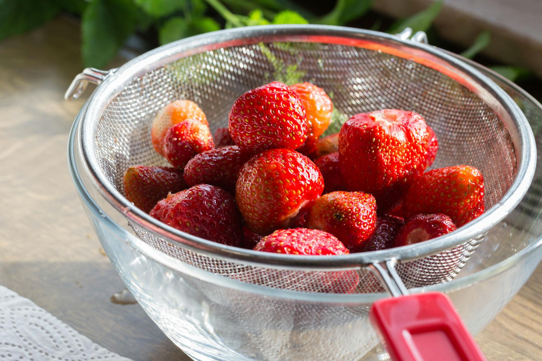 Erdbeeren richtig zu lagern, hält sie länger frisch. Ein Sieb ist dazu eine gute Option.