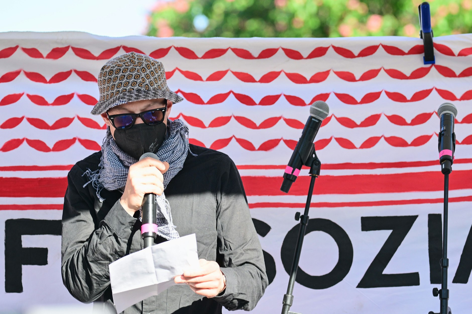 Ein Vermummter liest während der Revolutionären 1. Mai-Demo 2025 ein Grußwort von Daniela Klette vor.