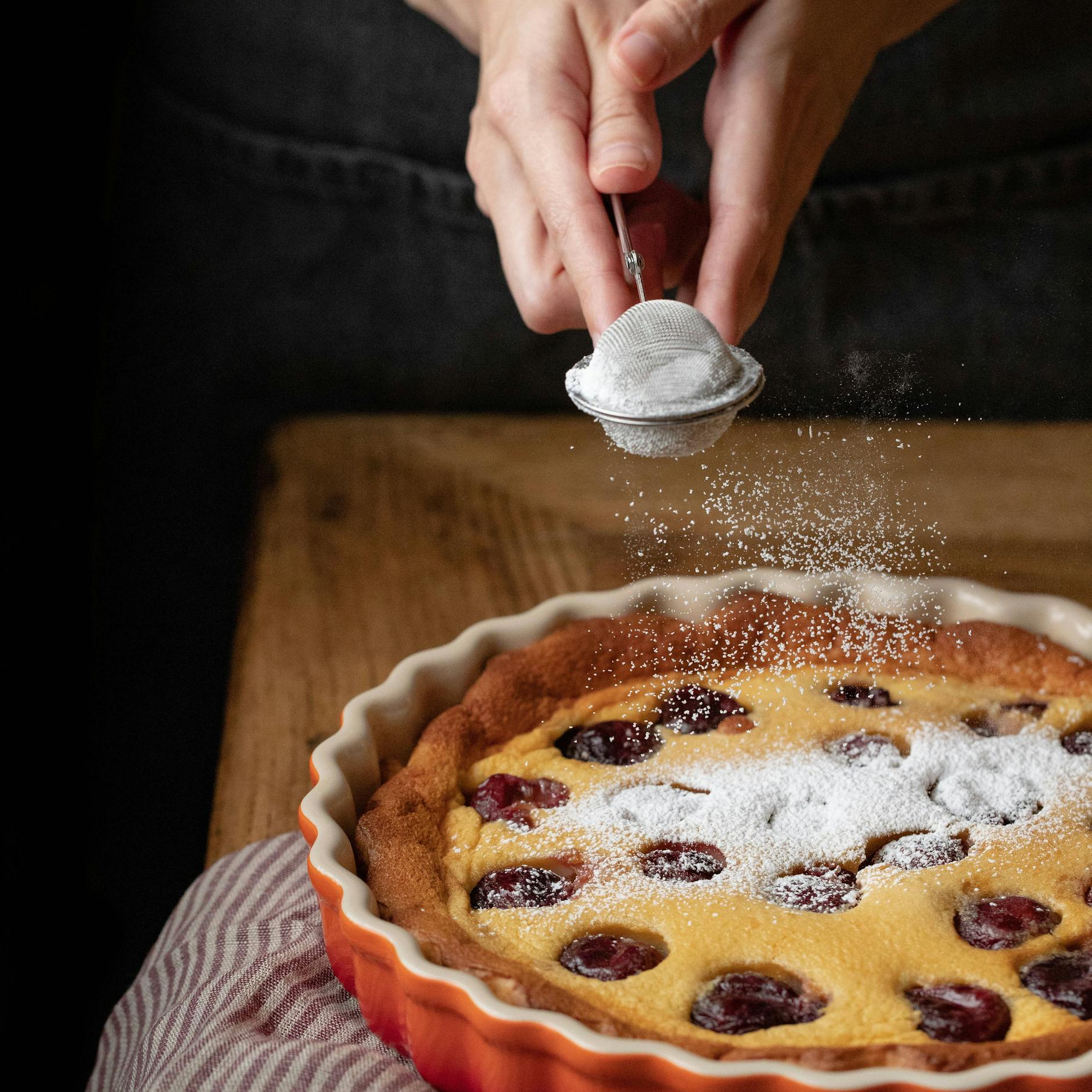 Sie können den Kirschkuchen noch mit etwas Puderzucker garnieren.
