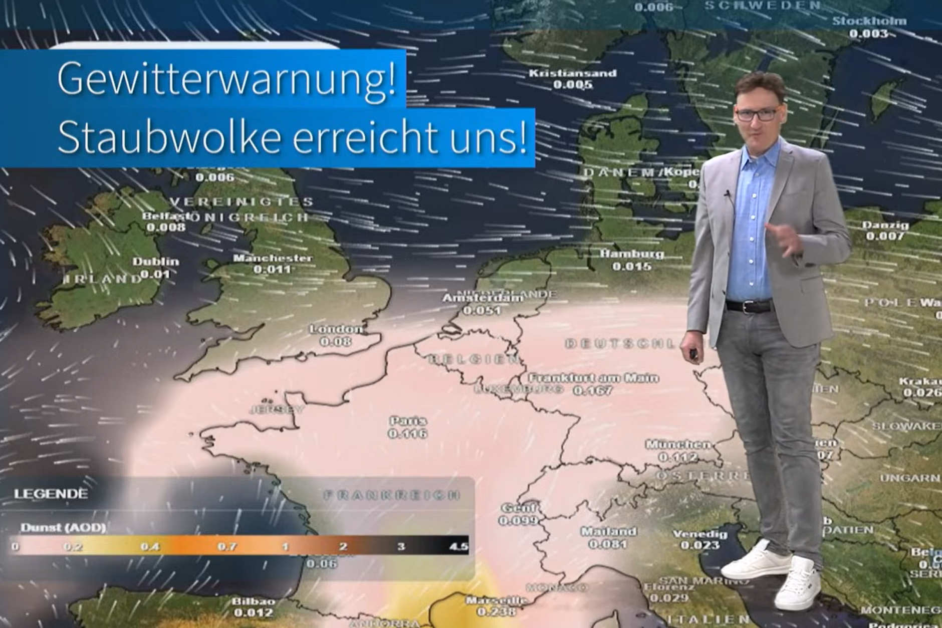 Meteorologe Dominik Jung von wetter.net steht vor der Wetterkarte, die die Ausbreitung von Saharastaub in Europa und Deutschland anzeigt.