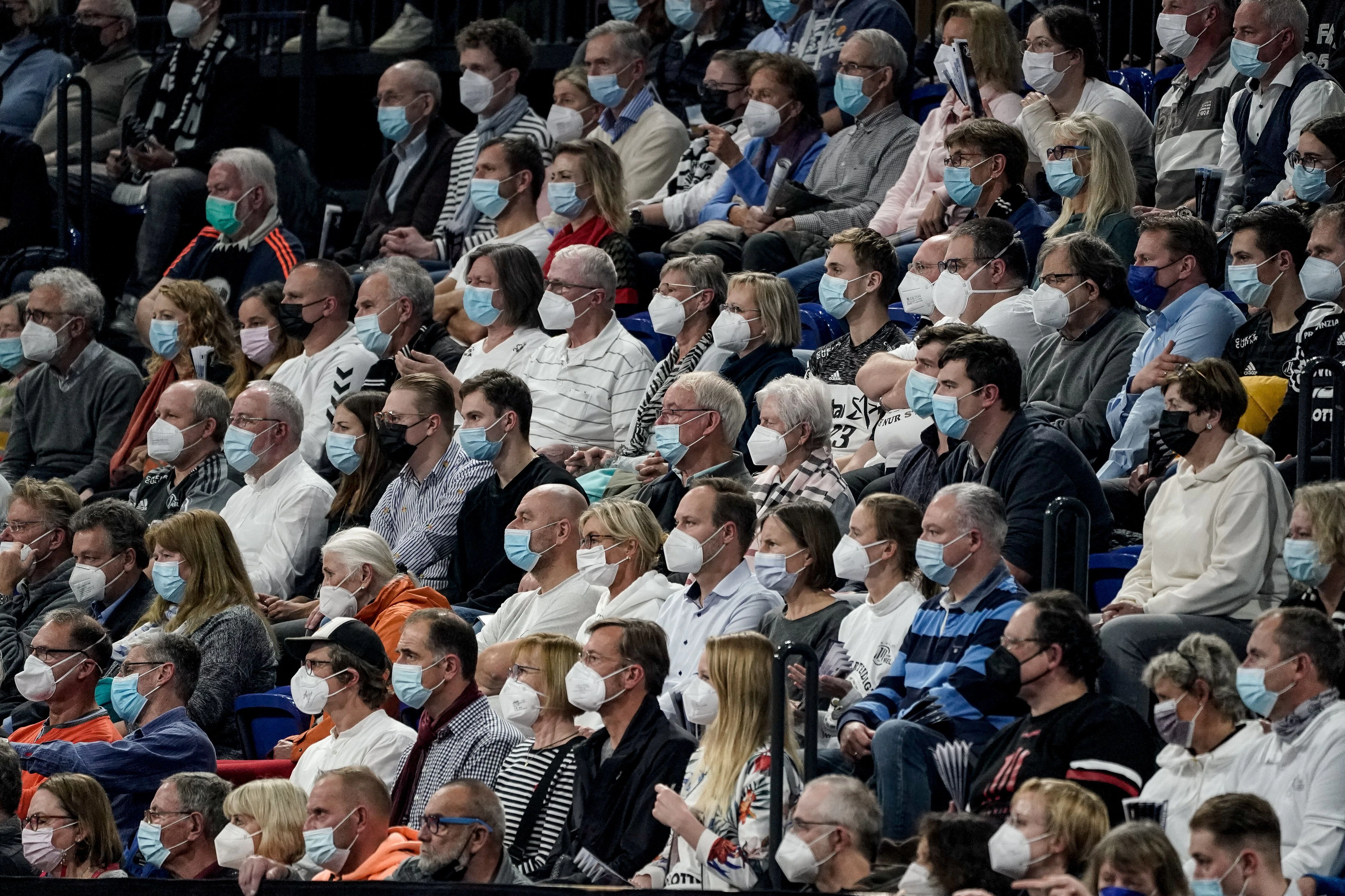 Zuschauer mit Atemschutzmasken bei einem Handballspiels während der Coronapandemie
