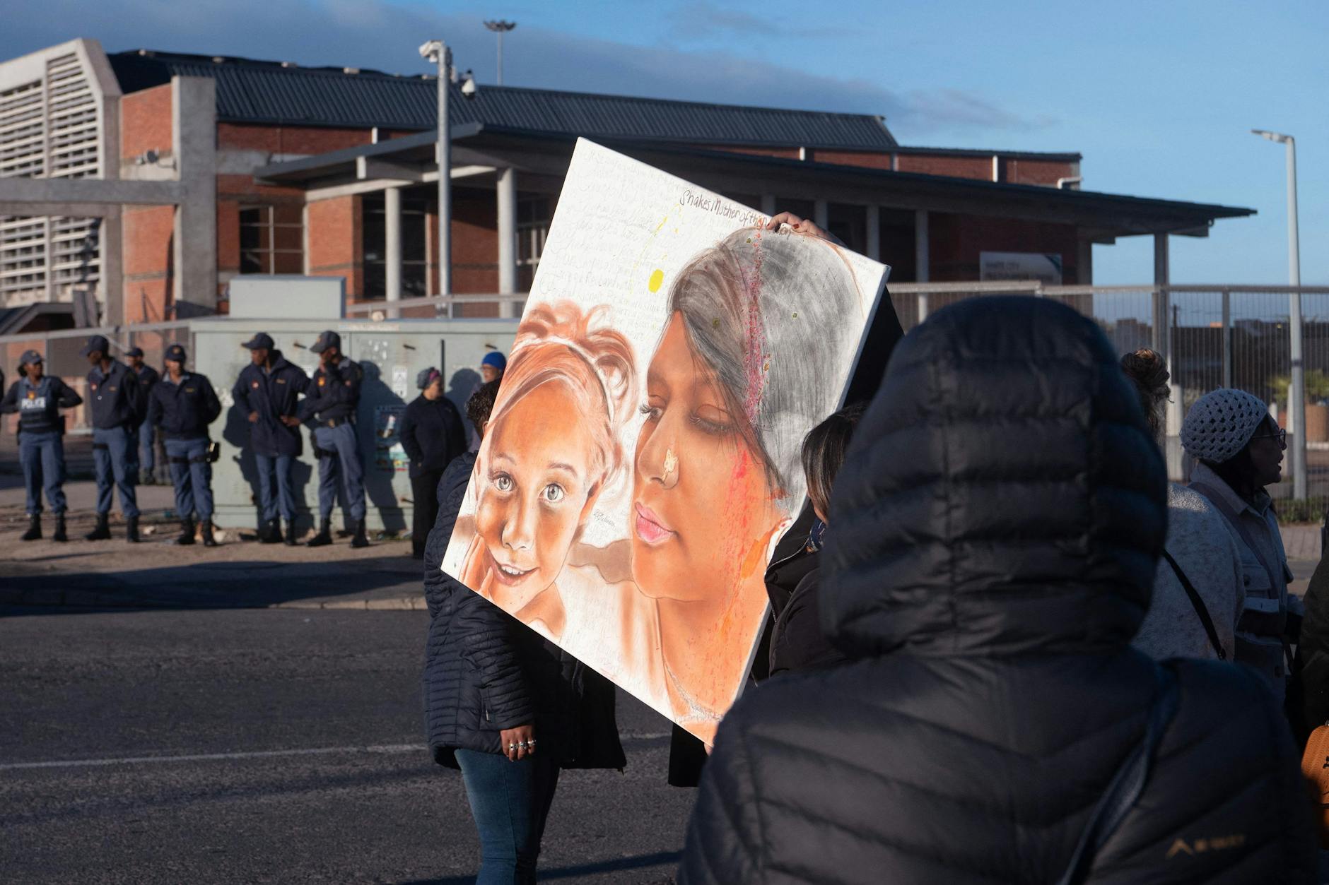 Am Rande des Prozesses in Südafrika zeigten Demonstrierende ein gemaltes Bild der sechsjährigen Joshlin. Wurde sie von ihrer Mutter wegen ihrer hellen Augen- und Hautfarbe verkauft?
