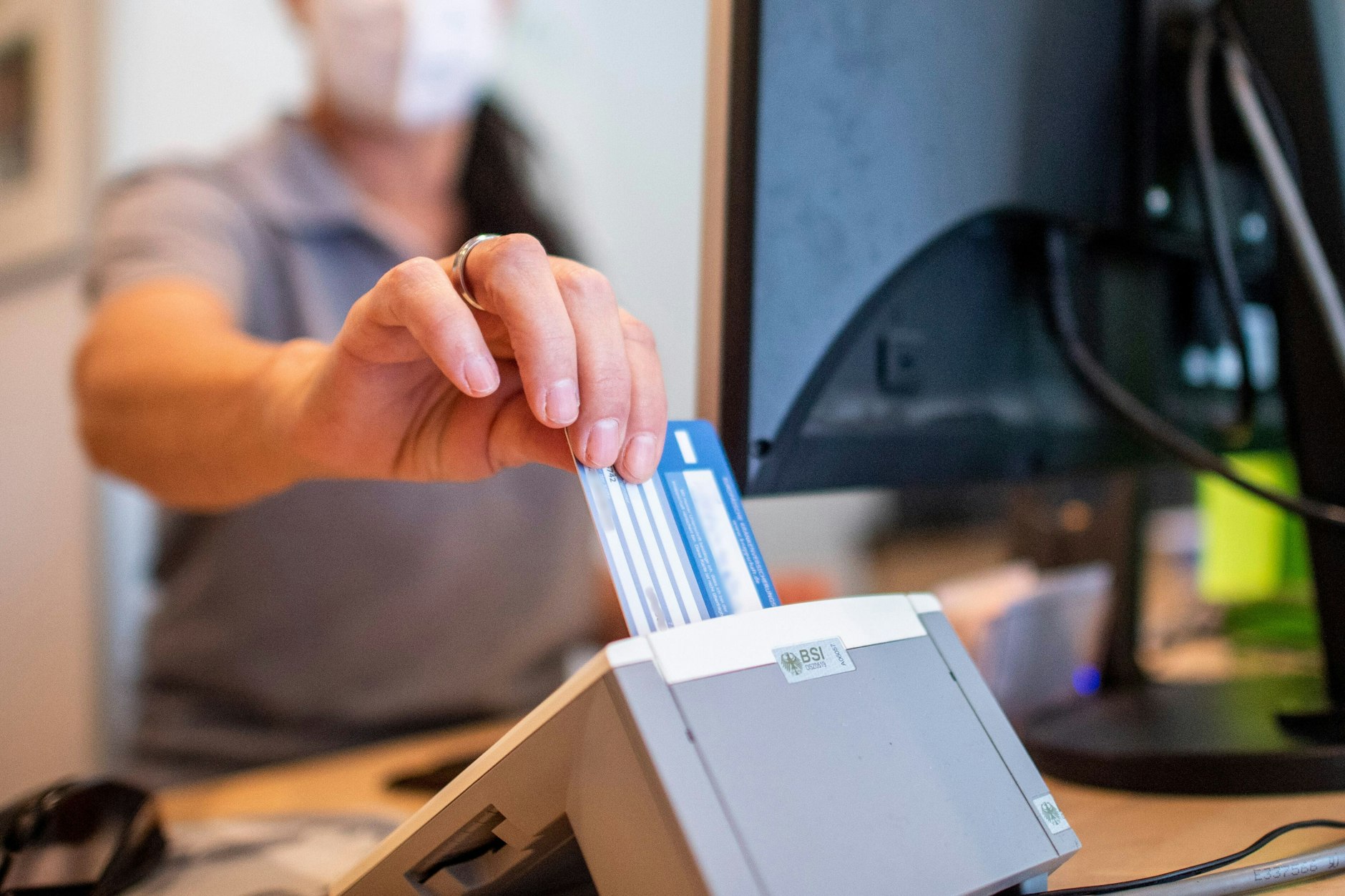 Eine Person schiebt eine Versichertenkarte einer Krankenkasse in ein Lesegerät. Elektronische Rezepte und digitale Patientenakten wurden nach jahrelangen Verzögerungen eingeführt.