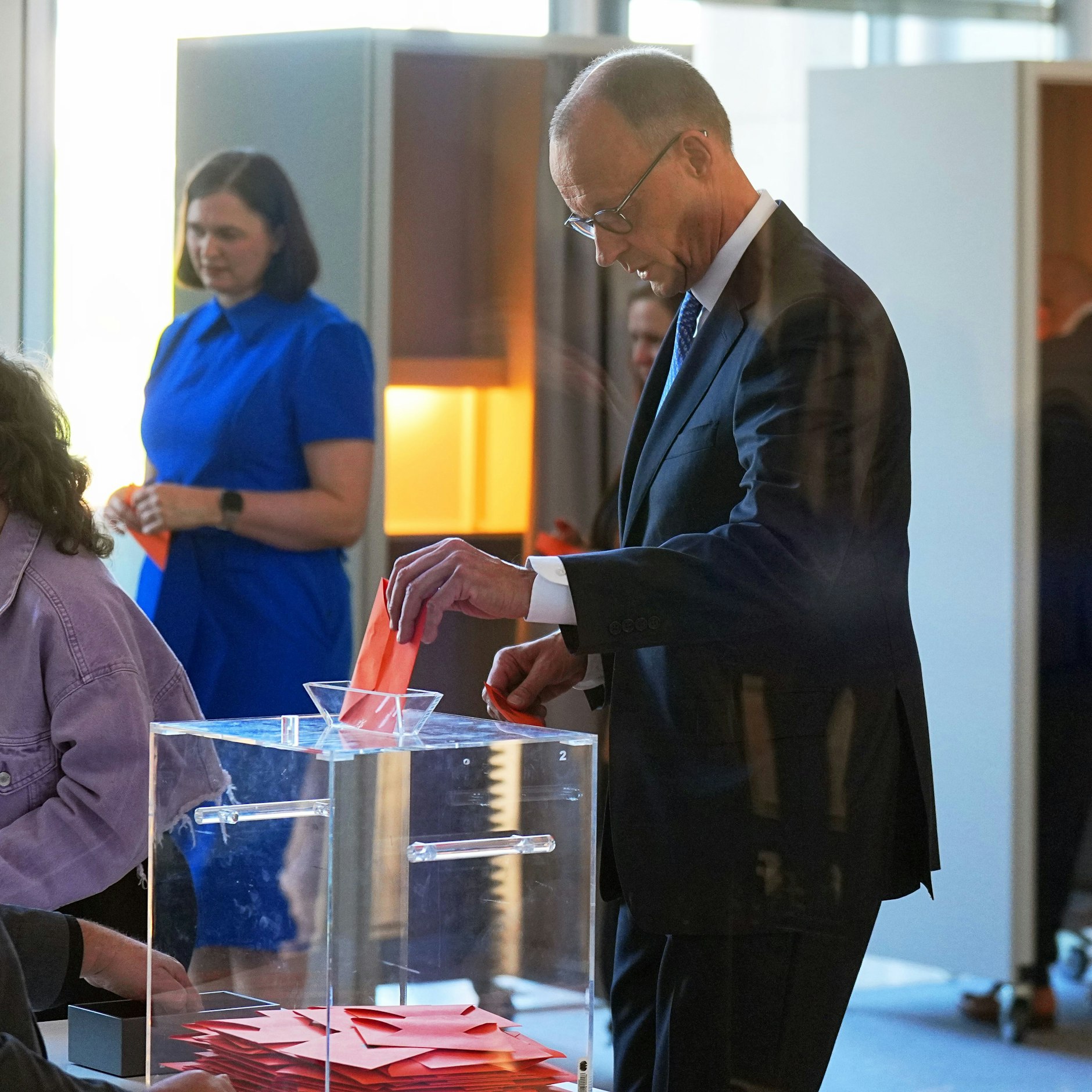 Der designierte Bundeskanzler Friedrich Merz (CDU, M) gibt im Bundestag bei der Kanzlerwahl seinen Stimmzettel ab. 