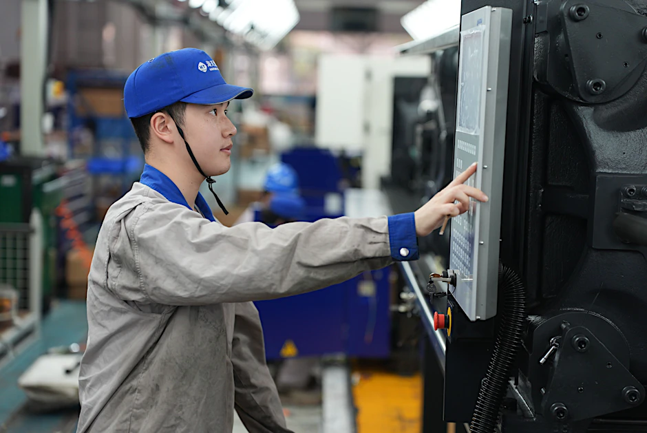 Ein Mitarbeiter arbeitet an der Produktionslinie von Spritzgießmaschinen in der Stadt Ningbo in der ostchinesischen Provinz Zhejiang. 